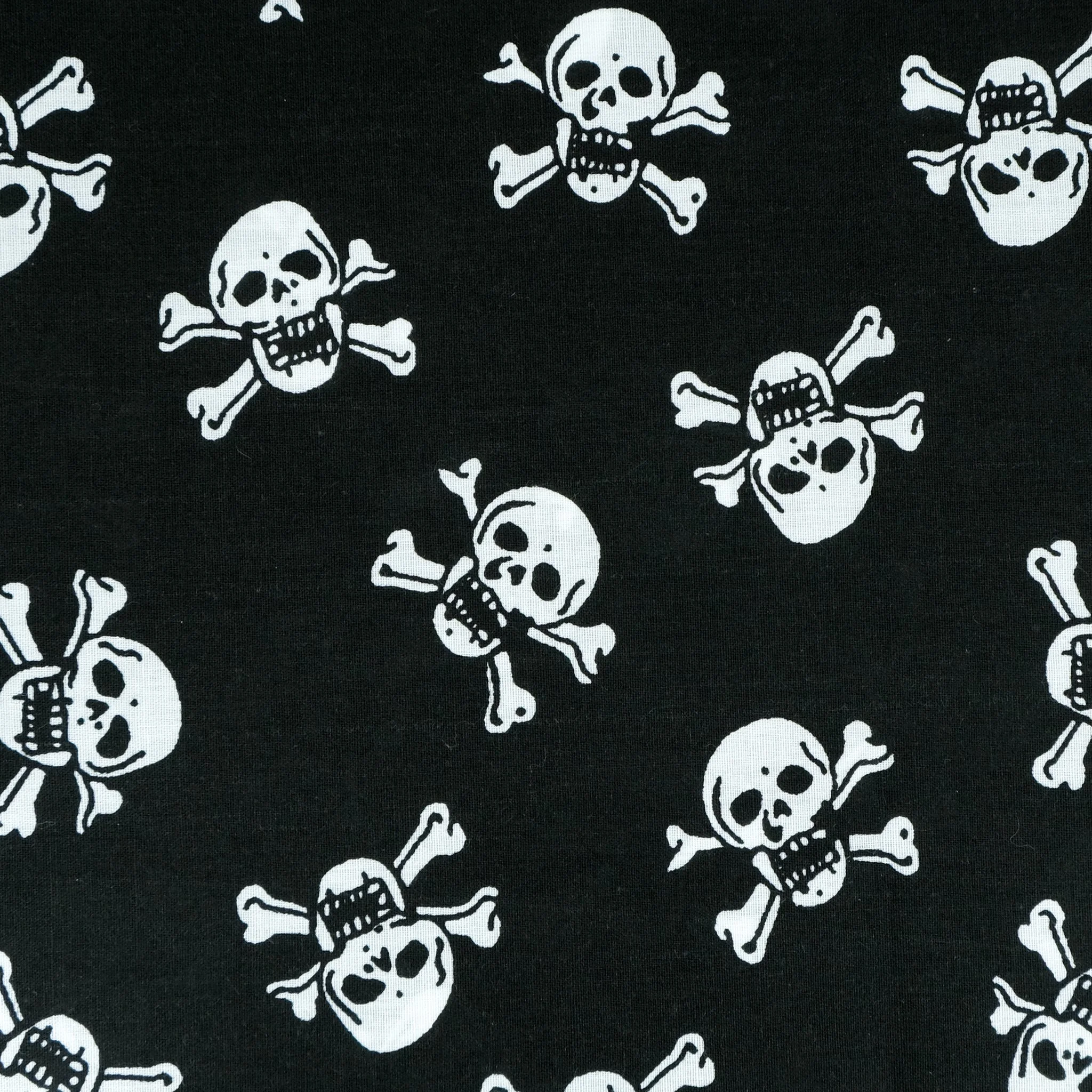 Fabric close up showing medium white skulls on black background, used for handmade Axis Range scrunchie by Creatoria Nyx