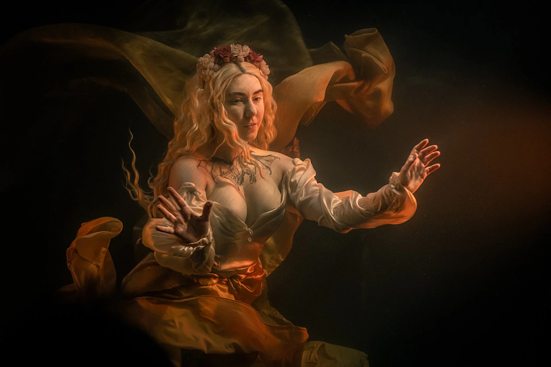 Liminal Drift Fantasy Photography by Catherine Knee. Underwater portrait of woman in flowing dress with golden light and drifting fabric creating dreamlike liminal atmosphere against dark background.