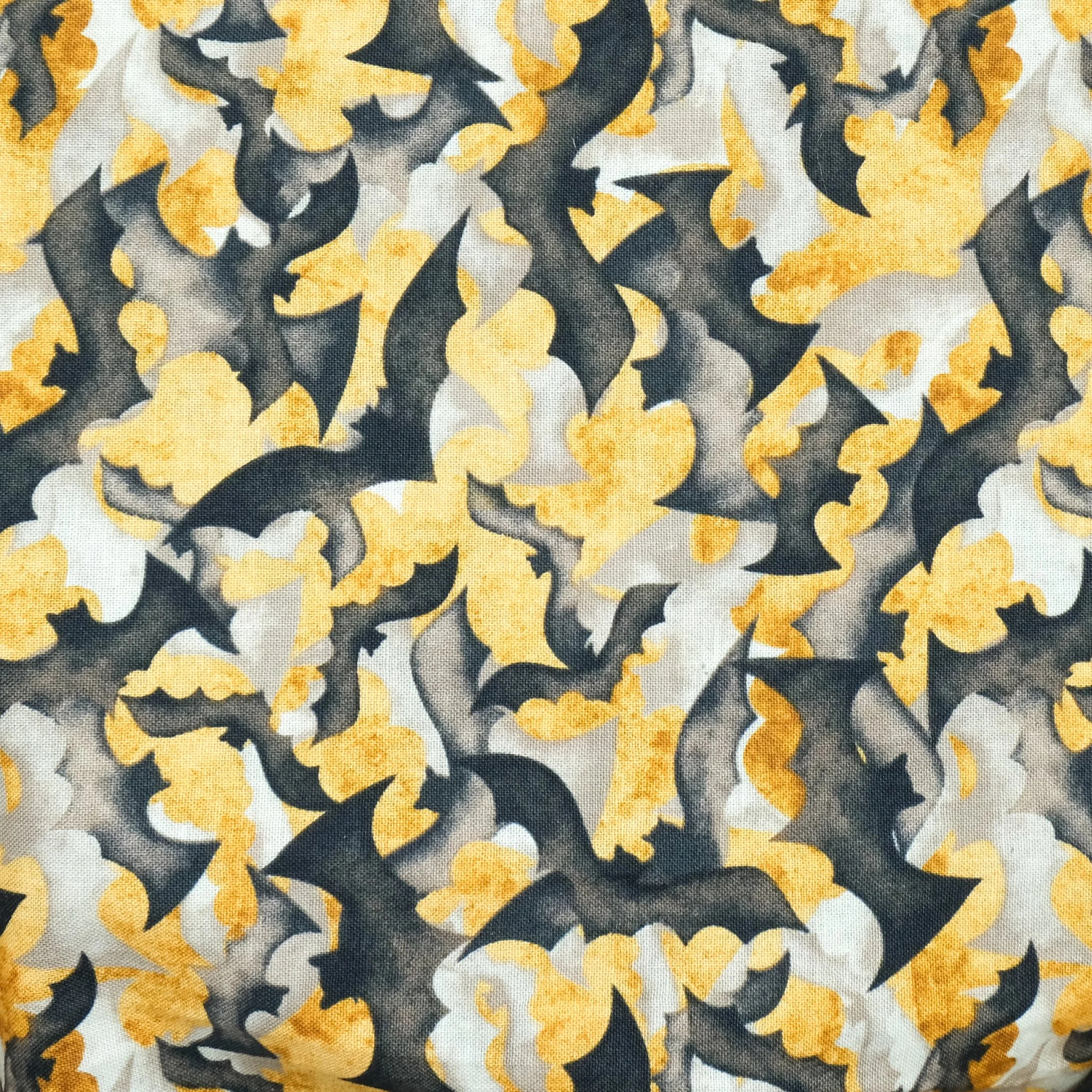 Fabric close up showing black and grey bats on orange background, used for handmade Axis Range scrunchie by Creatoria Nyx