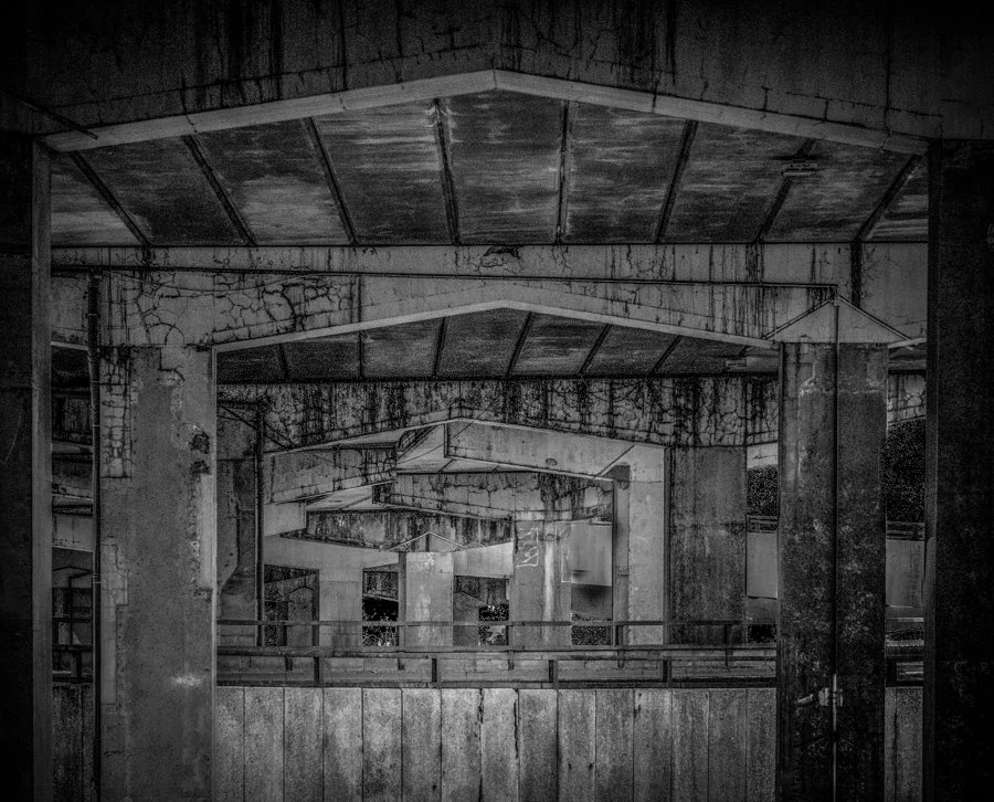 Weathered concrete structures beneath Coventry's ring road, with repeating lines and industrial textures receding into the distance.