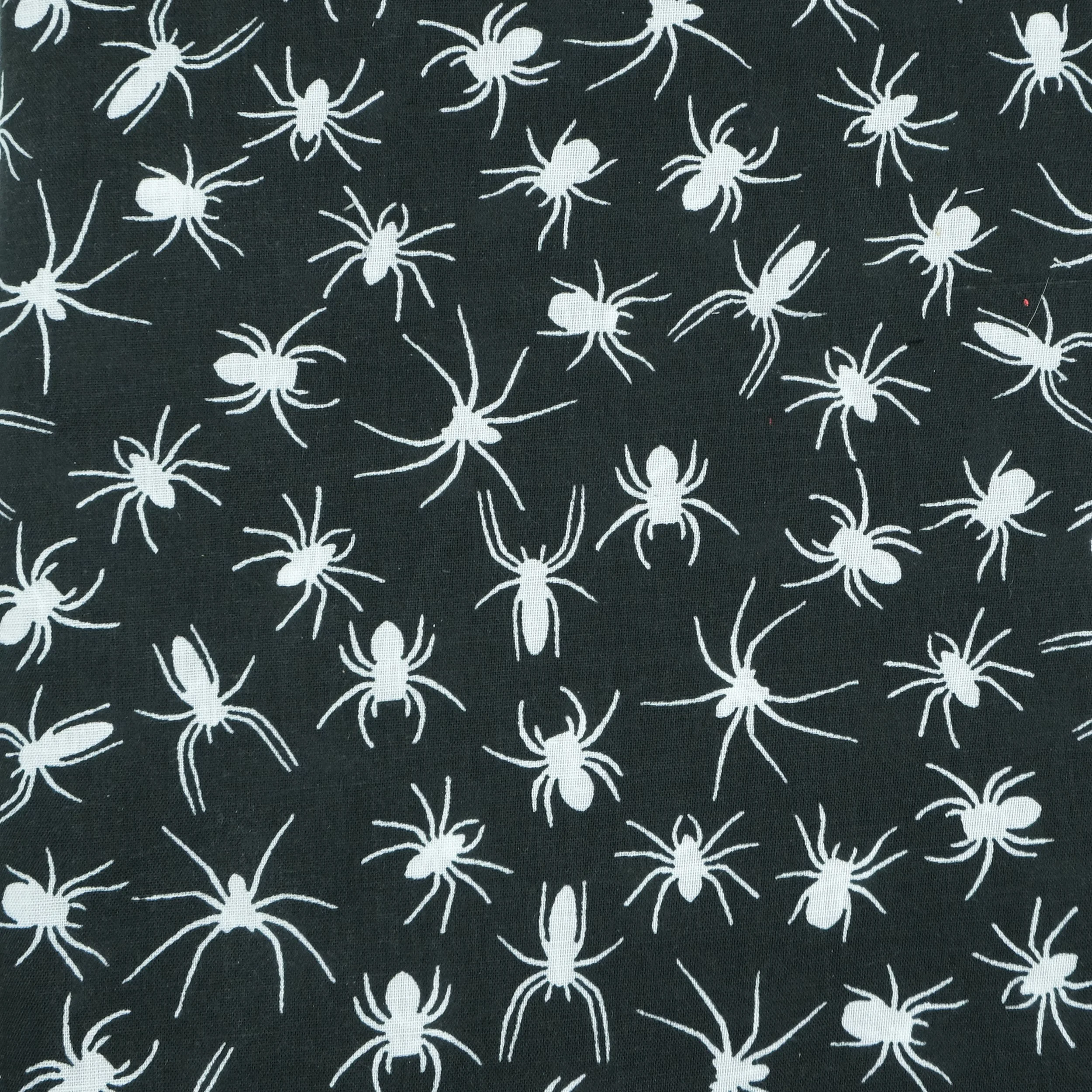 Fabric close up showing white spider silhouettes on black background, used for handmade Axis Range scrunchie by Creatoria Nyx