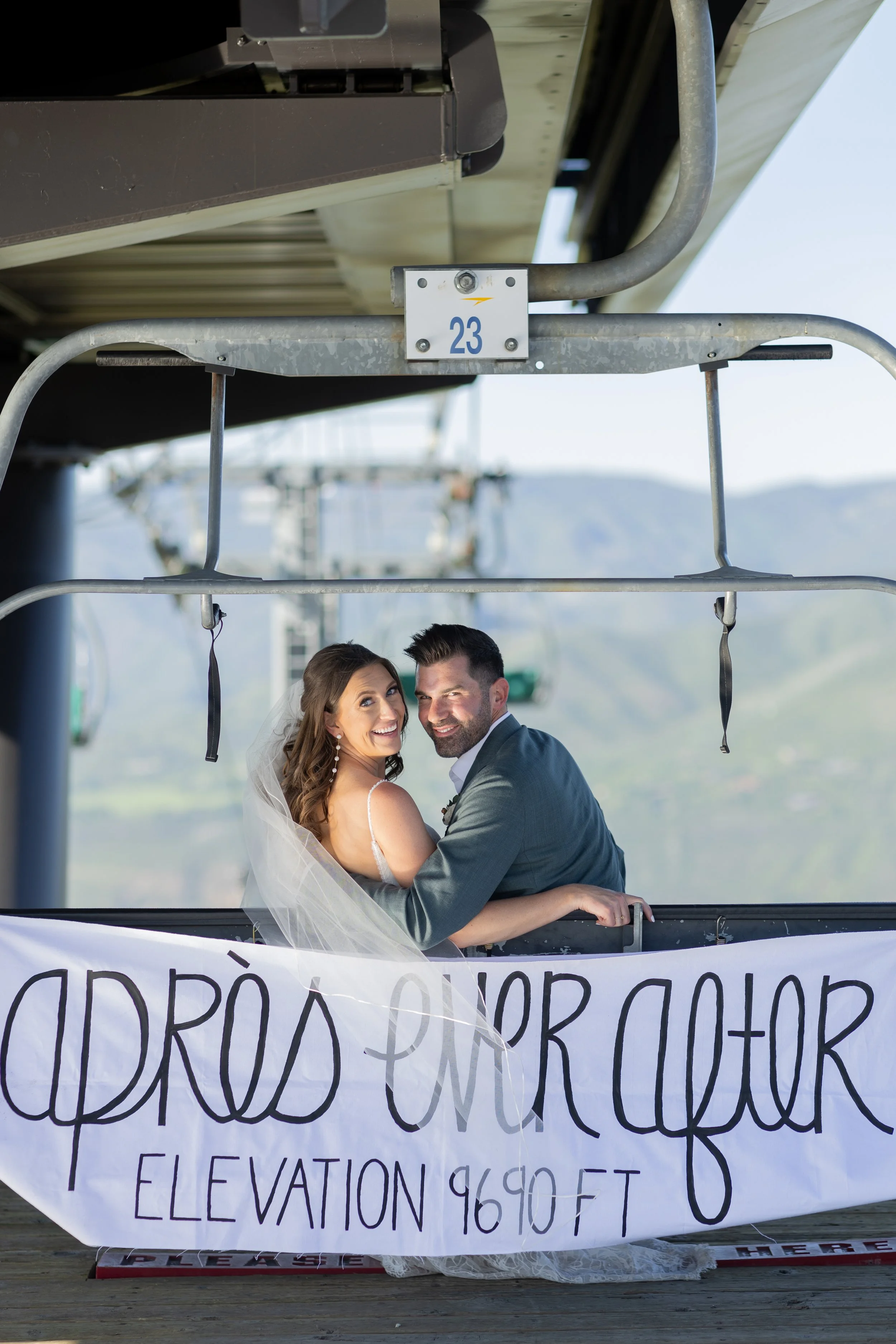 bride and groom in a ski life with sign