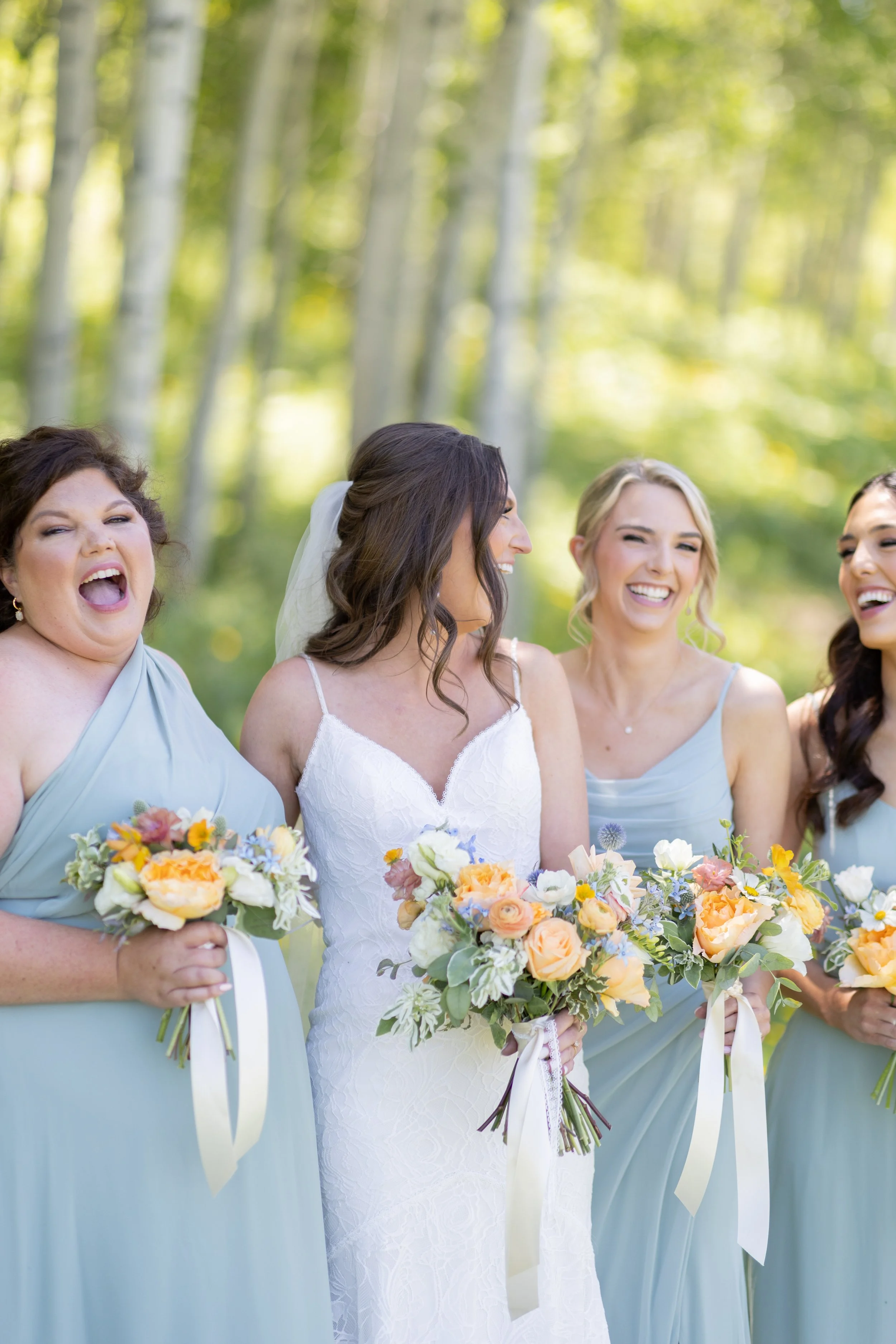 bride and bridesmaids standing together in mountains