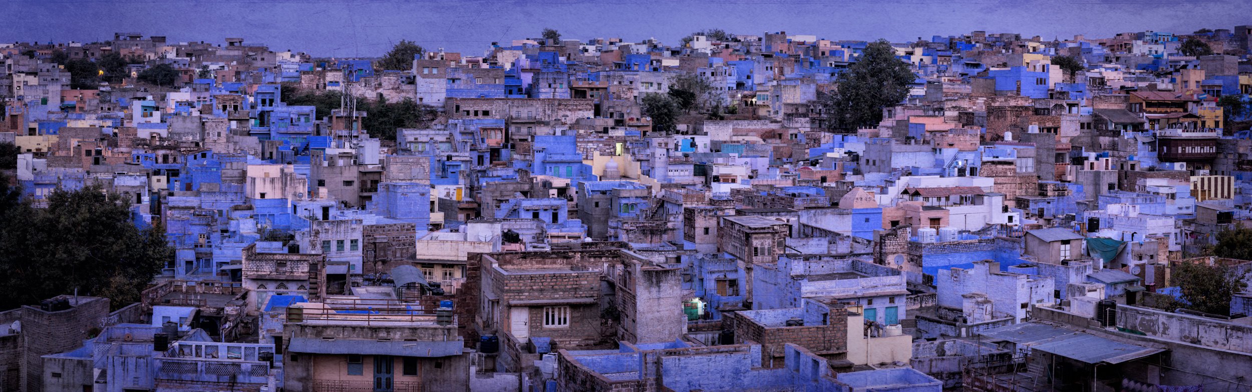 Jodhpur Blue City rooftop panorama in Rajasthan, showing dense blue-painted houses and urban architecture at twilight.