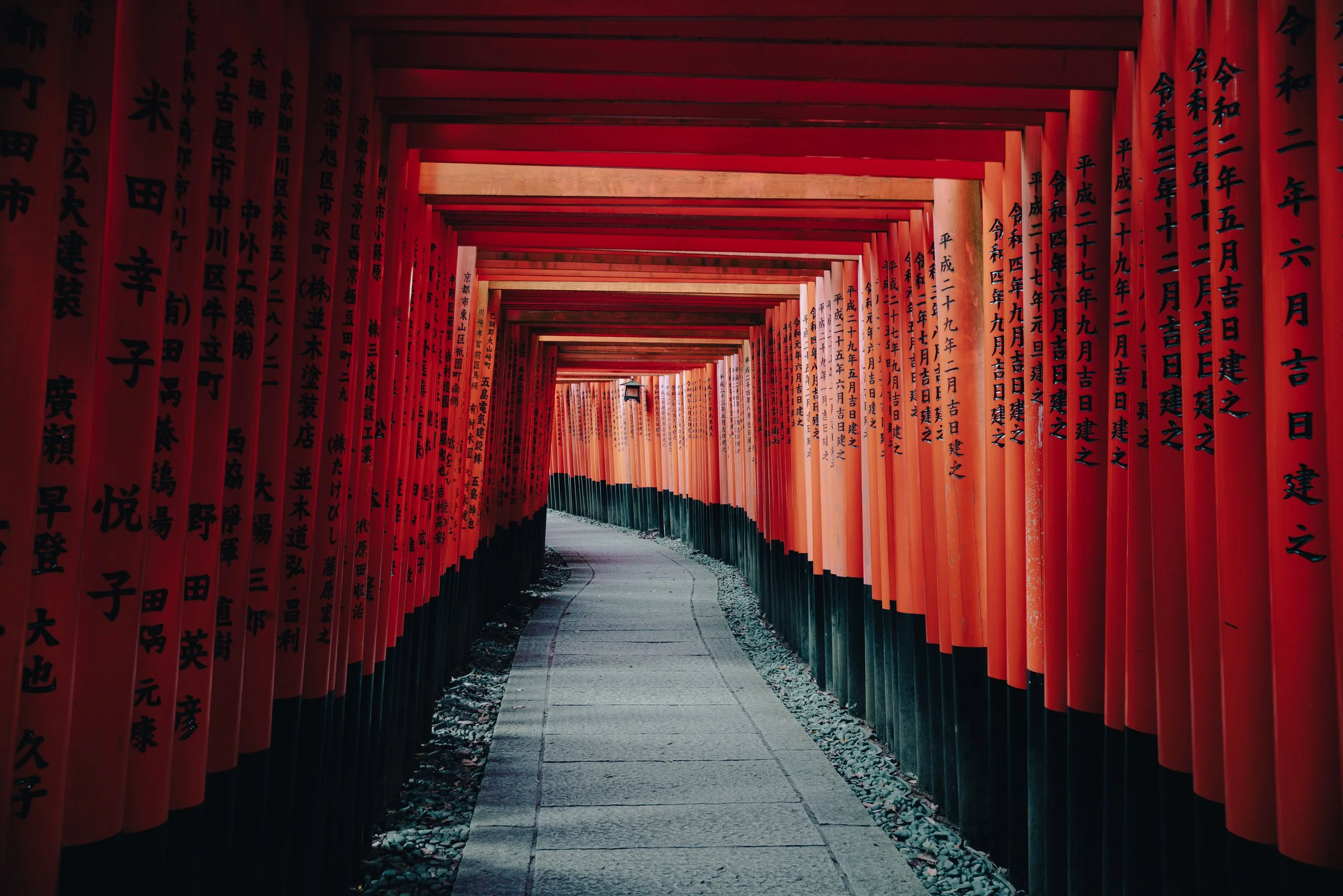 Fushimi Inari Shrine red torii gates forming a tunnel walkway in Kyoto, Japan.
