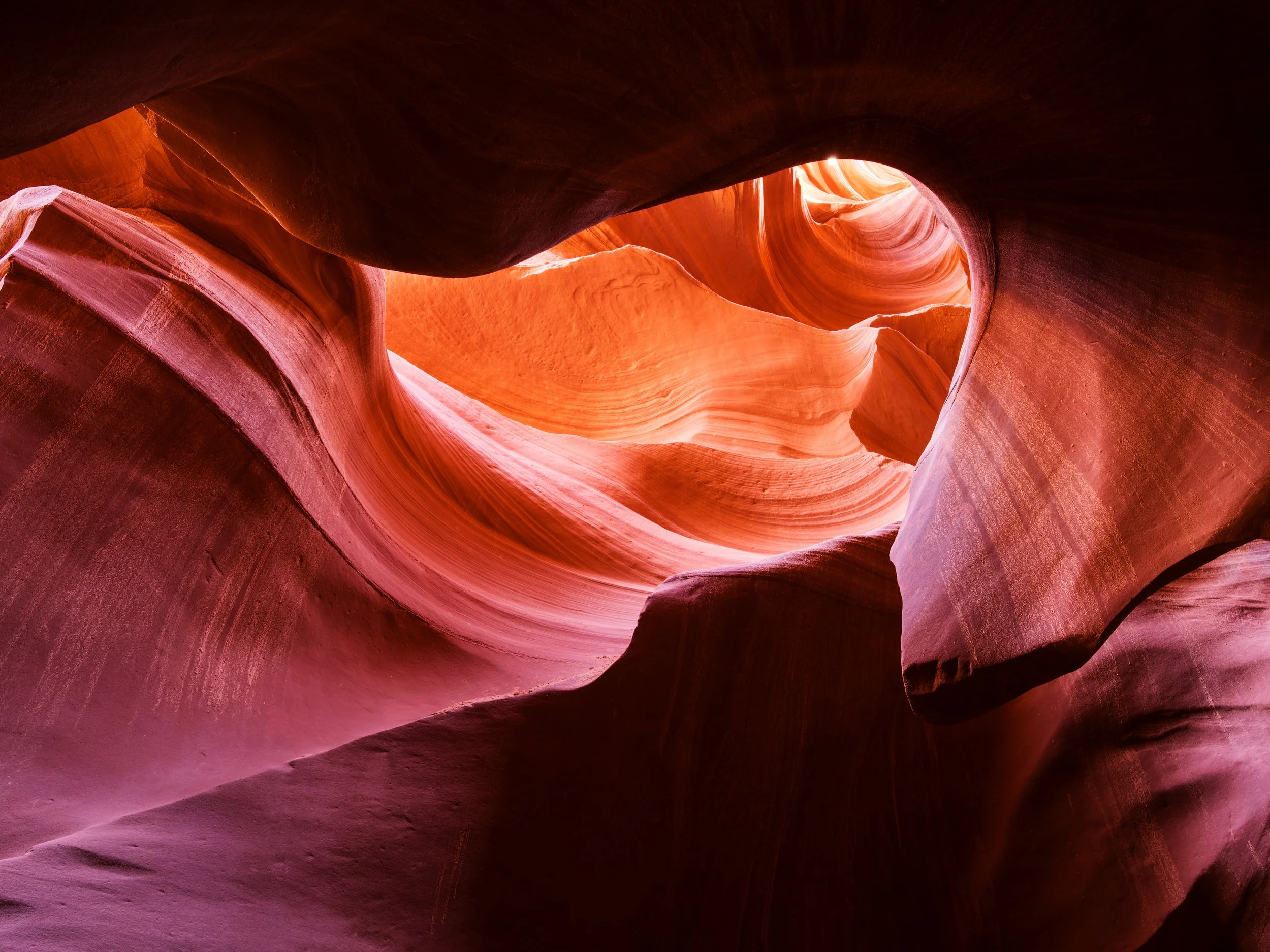 Glowing red and orange sandstone curves inside Antelope Canyon slot canyon in Arizona, USA.