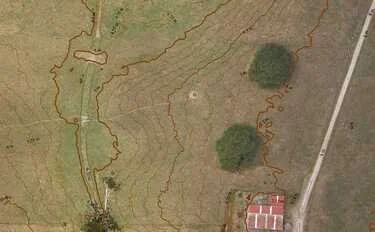 Topographic map showing elevation contours, trees, a building, and a road.
