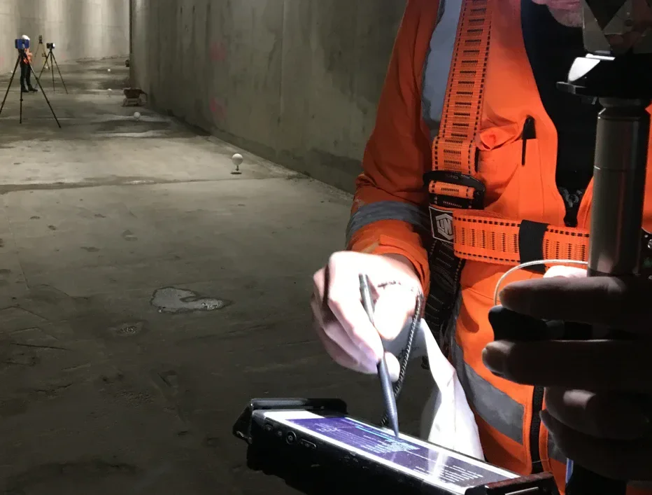 Recon surveyor capturing construction survey data in a concrete tunnel, New Zealand