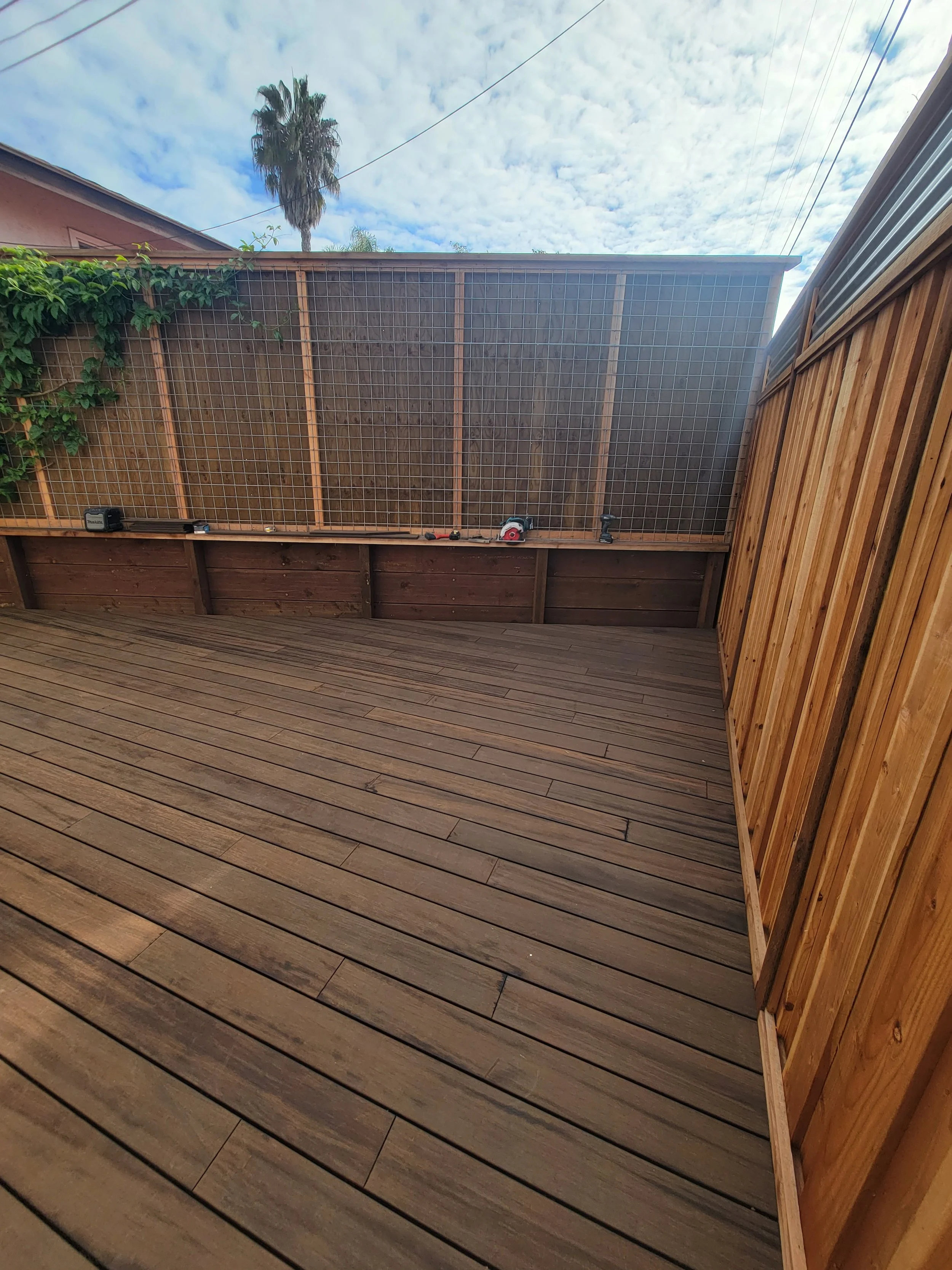 Low-profile hardwood deck built using MOSO bamboo decking boards with refined architectural layout, warm caramel coloration, and privacy wall integration for functional outdoor living.