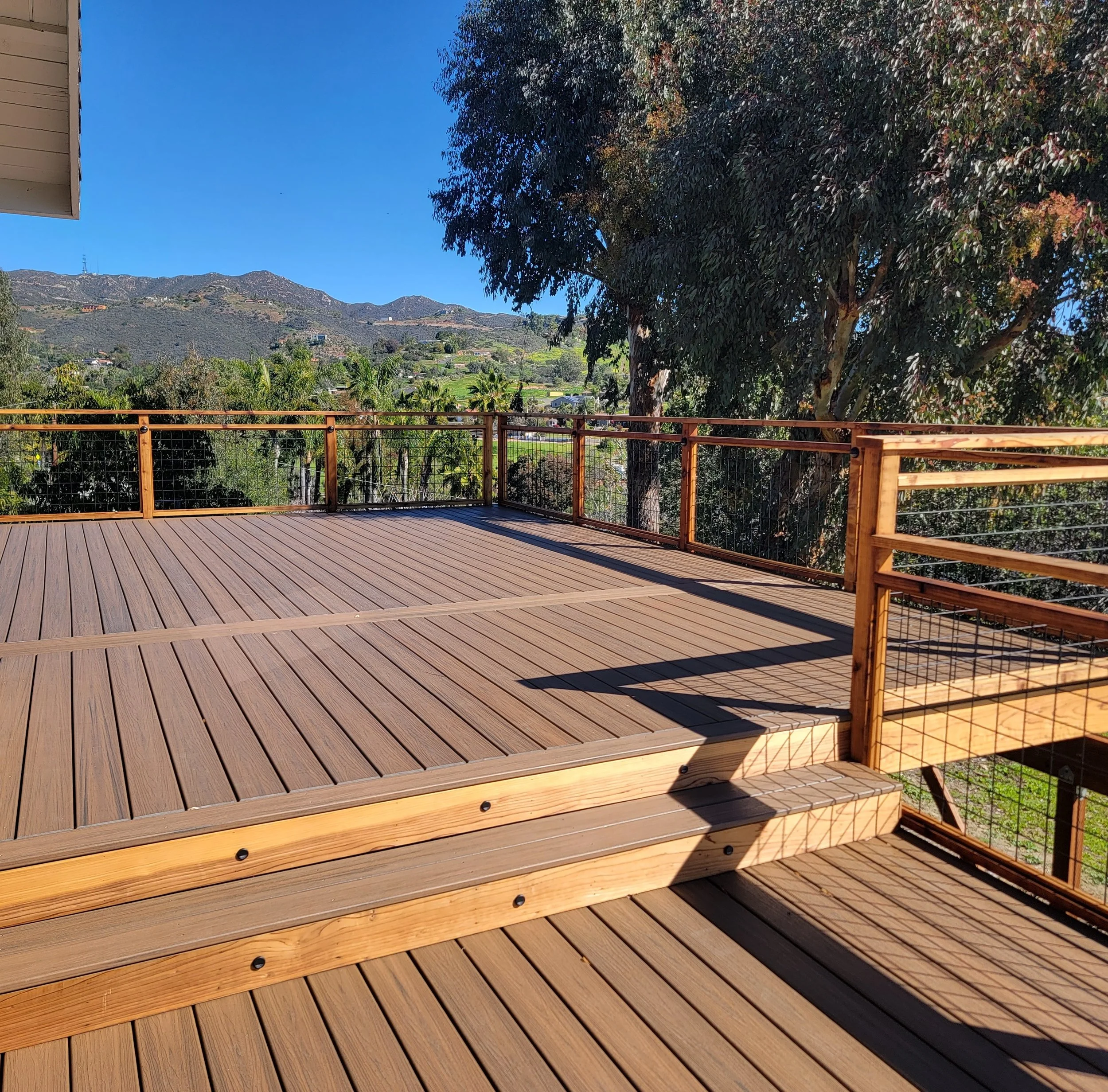 Modern Trex Toasted Sand composite deck with custom hog wire railing installed by Picano Builders in Vista, CA, overlooking a scenic valley.
