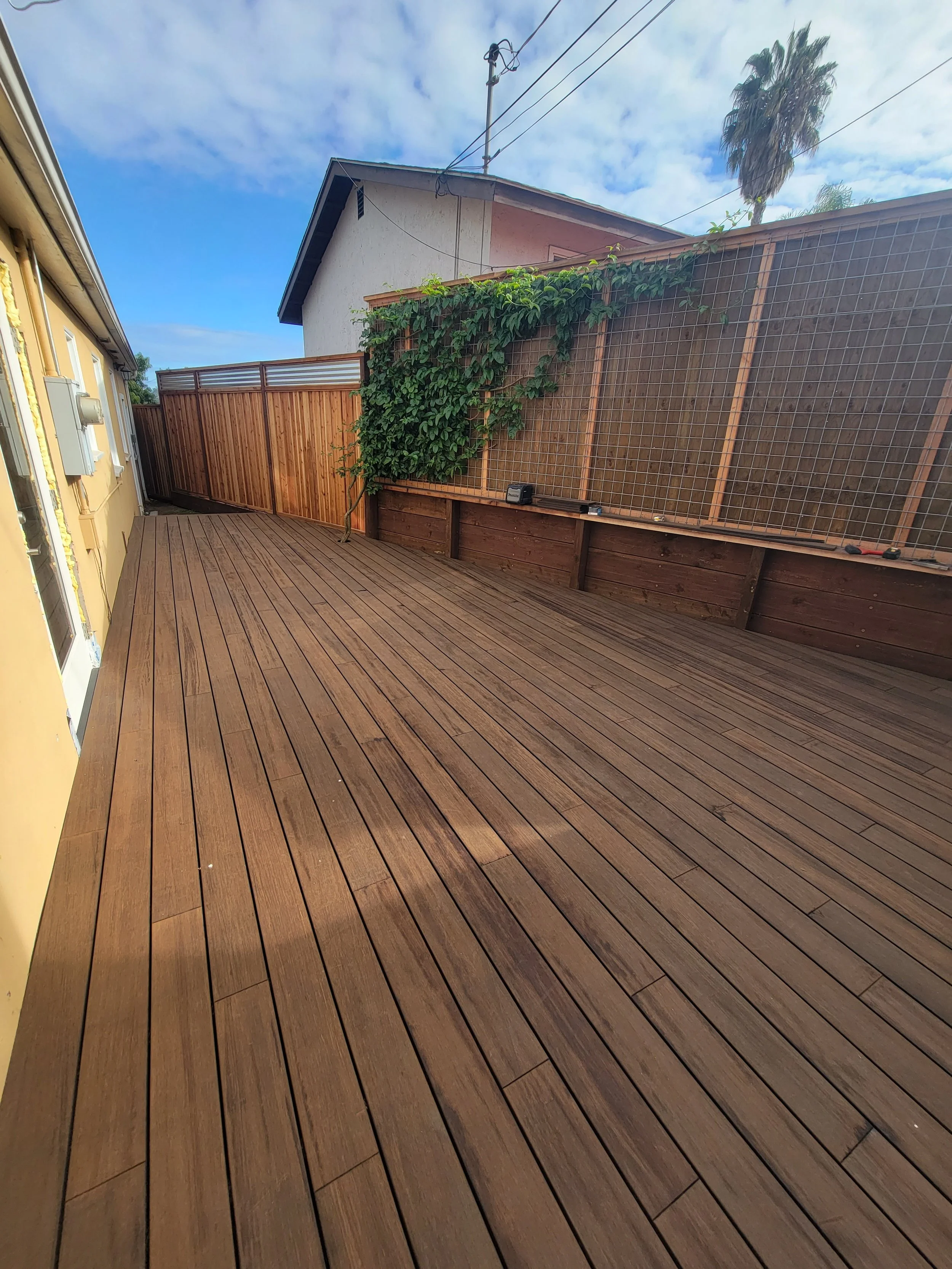 Architectural MOSO bamboo hardwood deck installed in a private backyard setting featuring narrow board layout, integrated privacy screening, and warm natural wood tones designed for long-term outdoor performance.