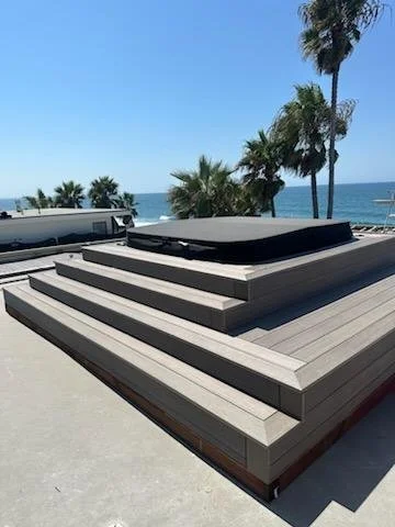 Multi-level composite rooftop deck with built-in hot tub and ocean views in Oceanside, CA, by Picano Builders.