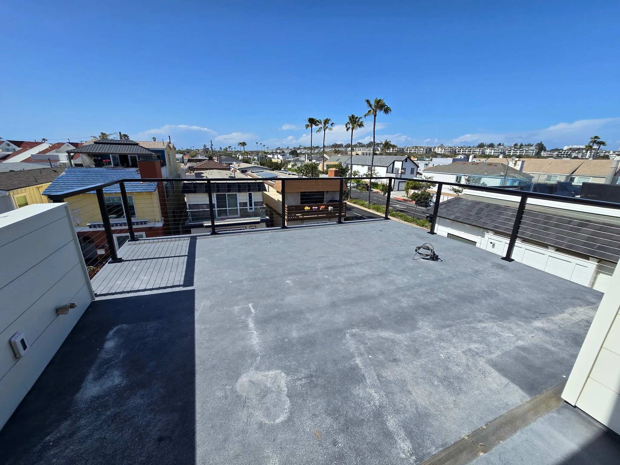Contemporary rooftop deck with Feeney cable railing installed by Picano Builders for a coastal Newport Beach residence.