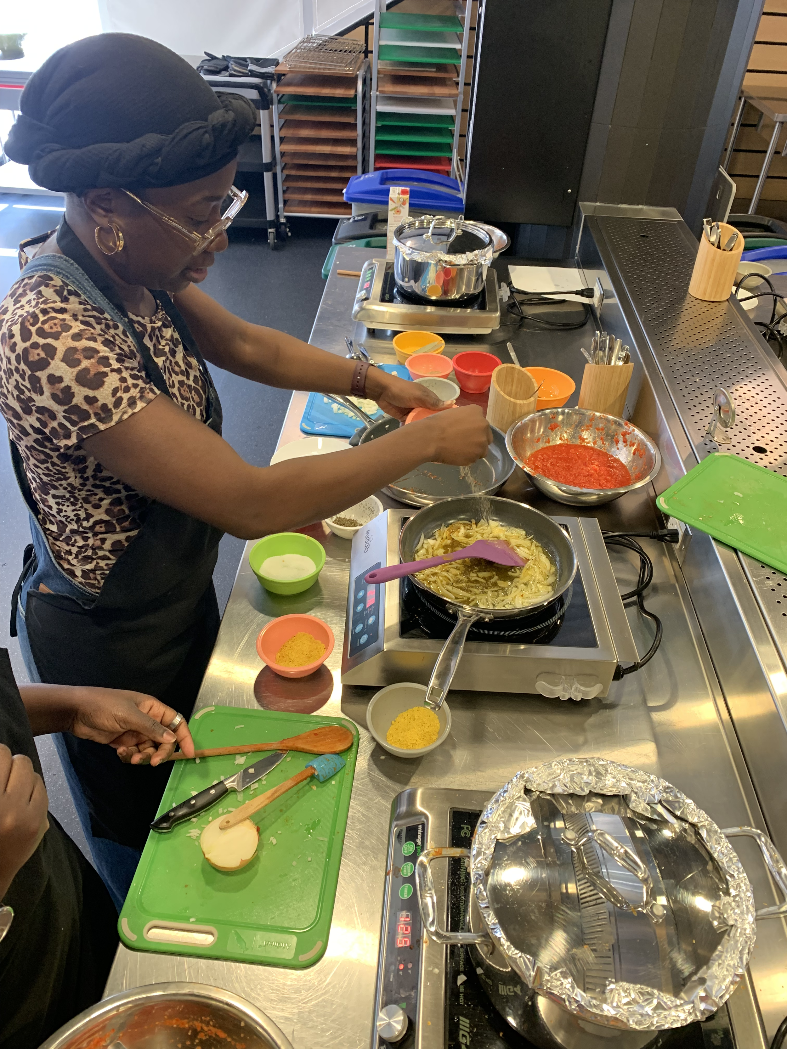 A Black women preparing food in a kitchen.