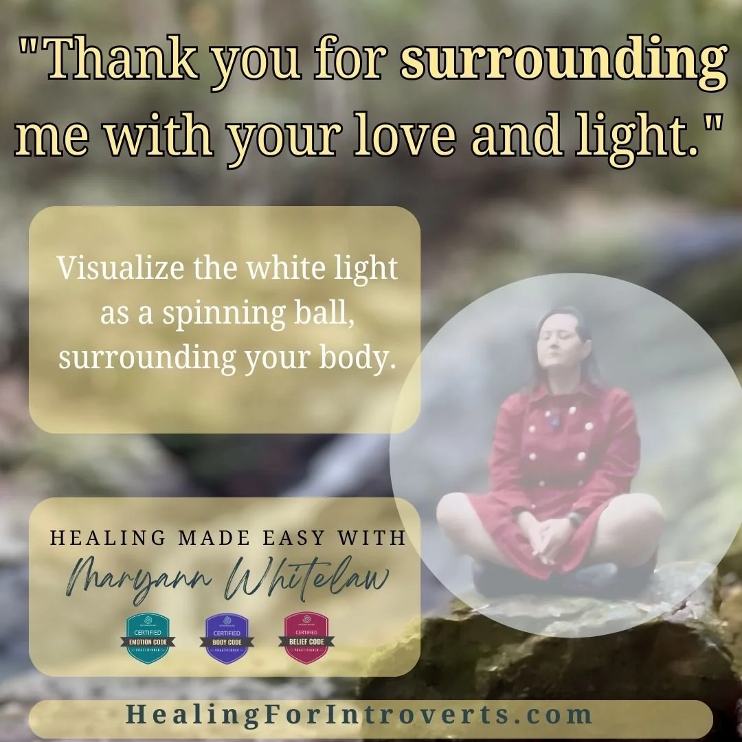 Woman in red coat meditating on rock. Energetic shielding advice.