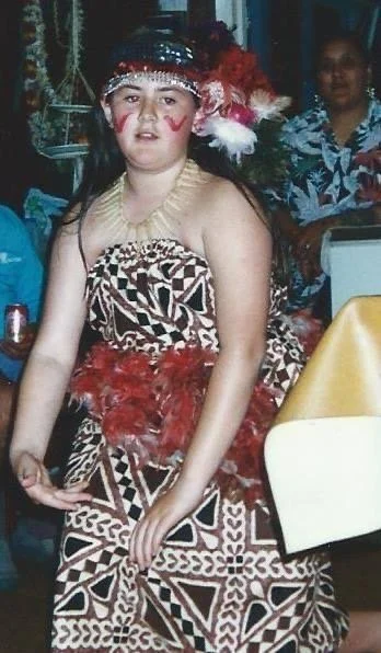 Dark haired girl dancing in traditional Samoan outfit