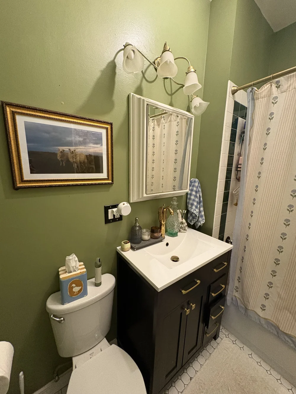 Landscape sheep print in a gold frame on a customer's green bathroom wall