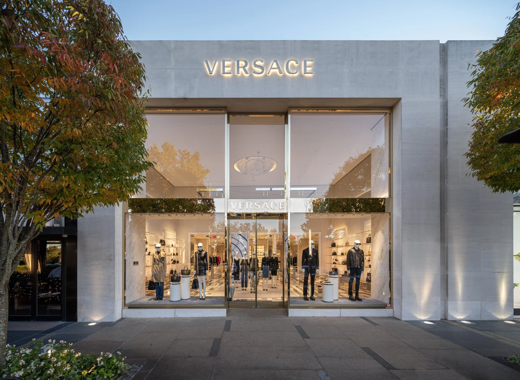 Versace and Rolex storefronts at Americana Manhasset photographed at golden hour and night — luxury retail architectural photography by Pavel Bendov, Manhasset NY