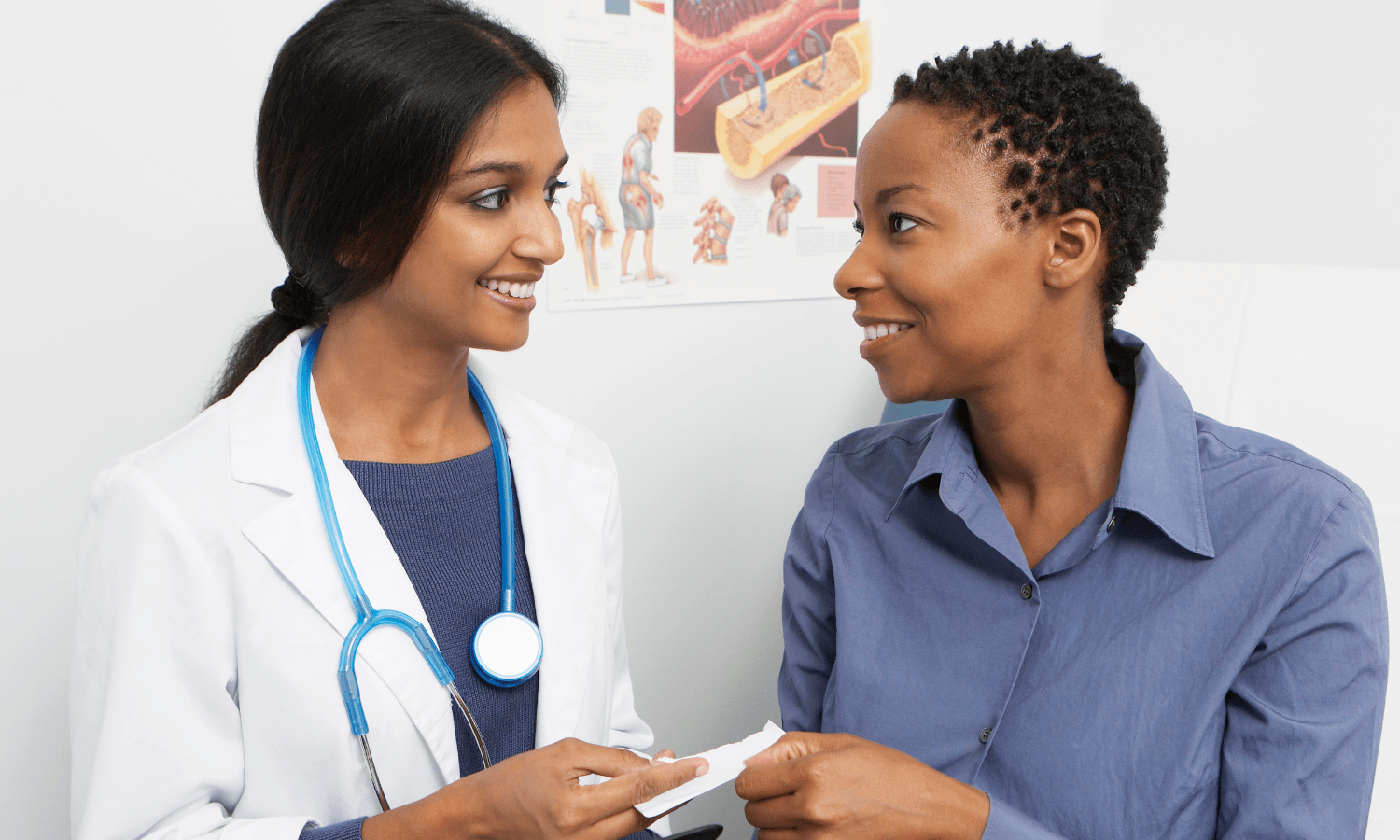 Two African American women discussing uterine fibroids in a doctor's office.