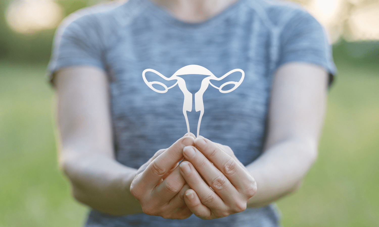 A woman is holding a uterus, concerned about the size of uterine fibroids.