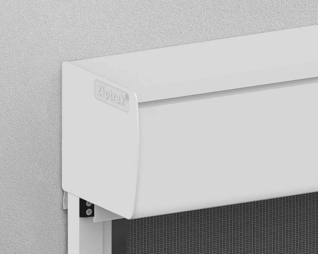 Close-up of a white Ziptrak outdoor roller blind mounted on a textured wall.