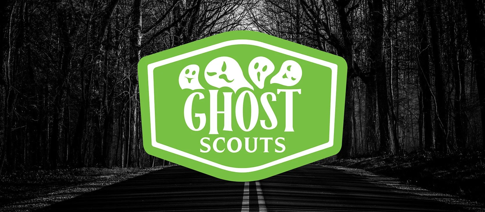 Green crest logo for Ghost Scouts with spooky smiling ghost faces at the top, set against a dark, eerie forest background with leafless trees and a road.