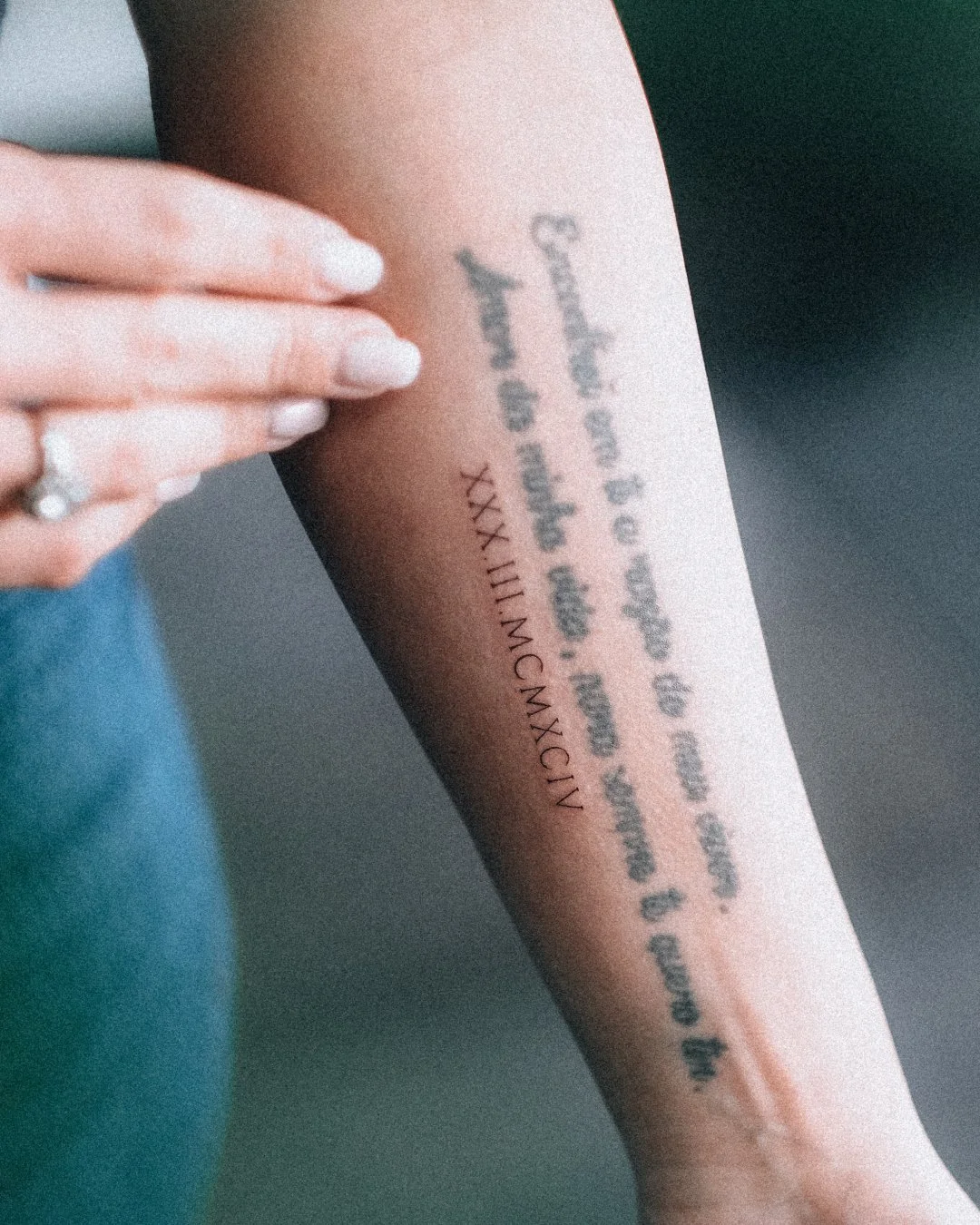 Fine line Roman numeral tattoo on the arm by Leandro Correia in Zurich