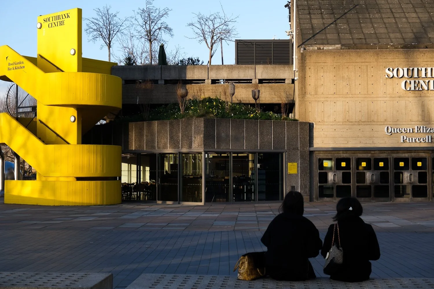 Two women on a bench opposite Haven, the wildflower pocket meadow at the Southbank Centre