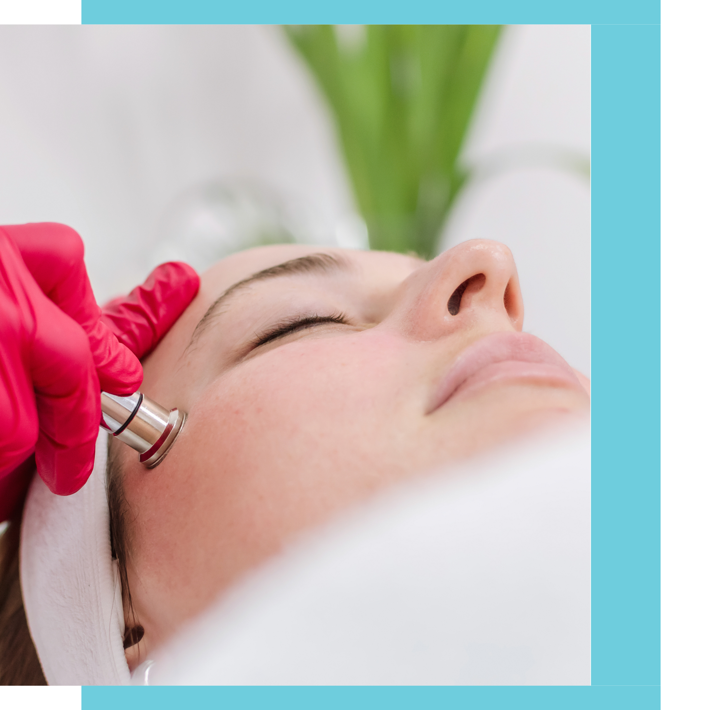 A woman receiving a facial treatment with a skincare device on her cheek, lying down with closed eyes, in a spa or clinic setting.