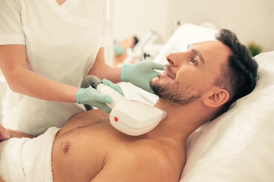 A man lying down recieving Laser Hair Removal treatment