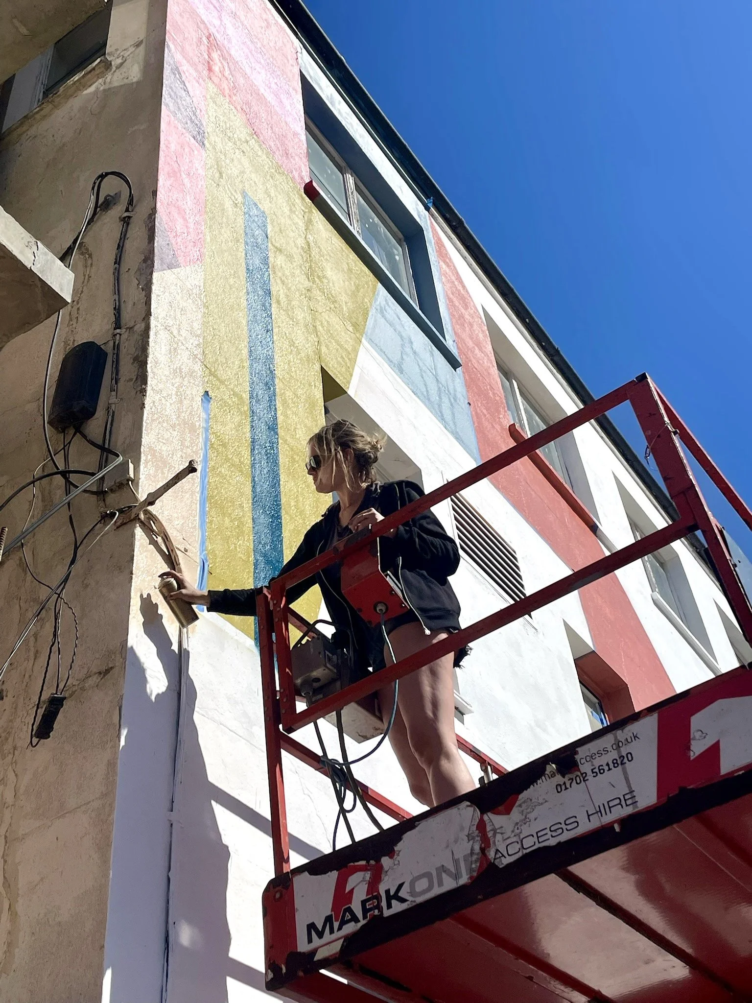 Mural artist Ansley Randall creating a large-scale architectural artwork at Southend City Jam 2026.