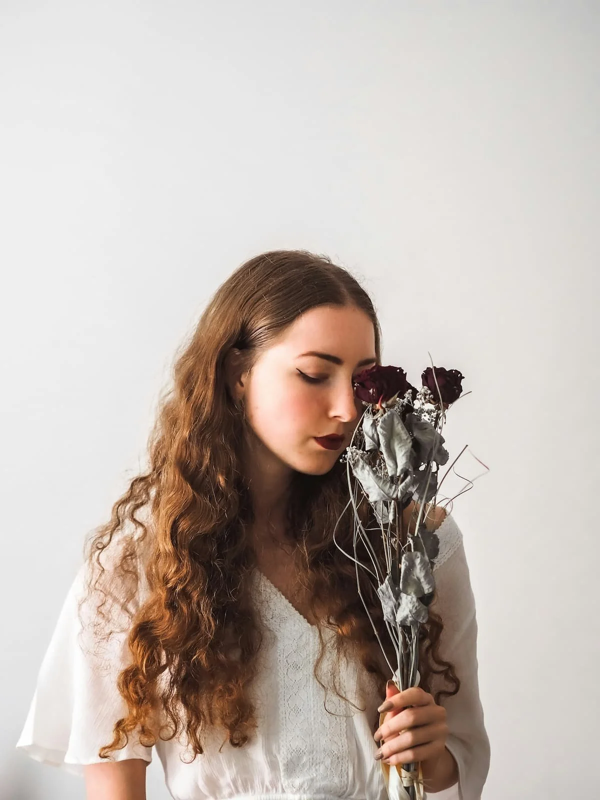 Woman holding wilting flowers during postpartum depression therapy in Miami FL