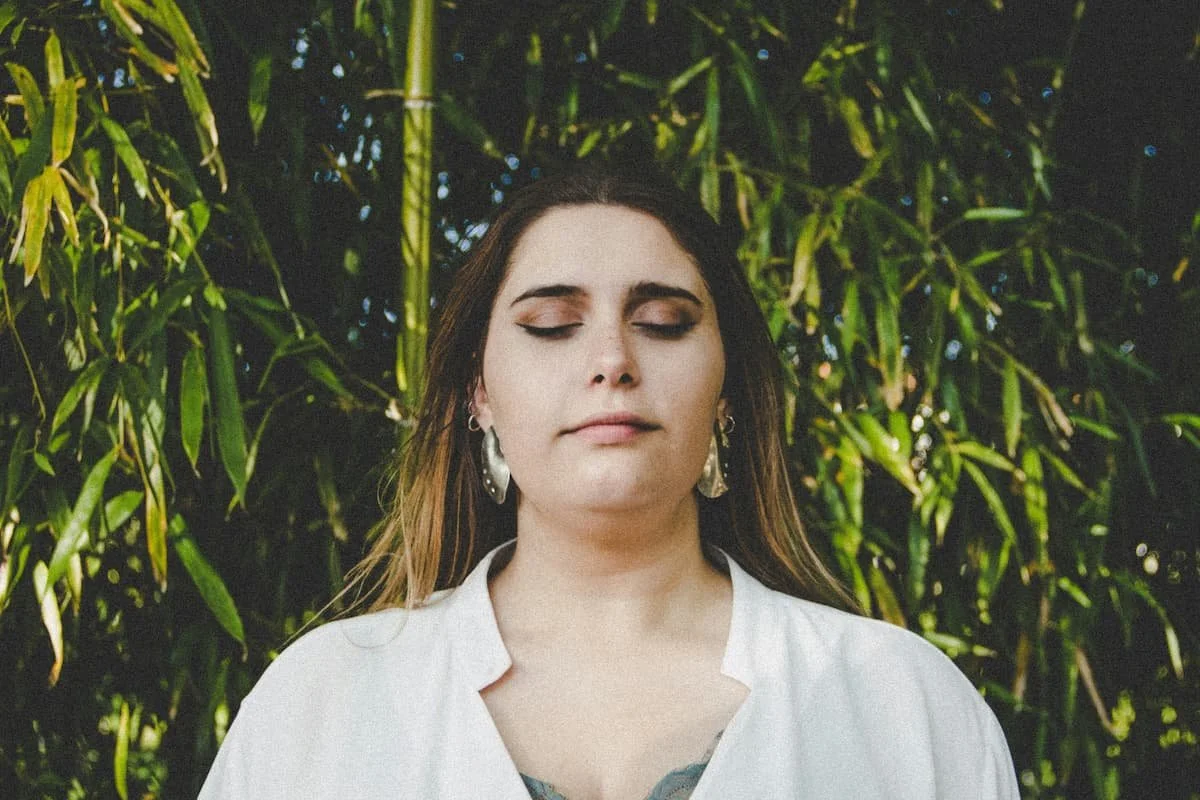 Woman with eyes closed finding relief after birth trauma therapy in Miami FL