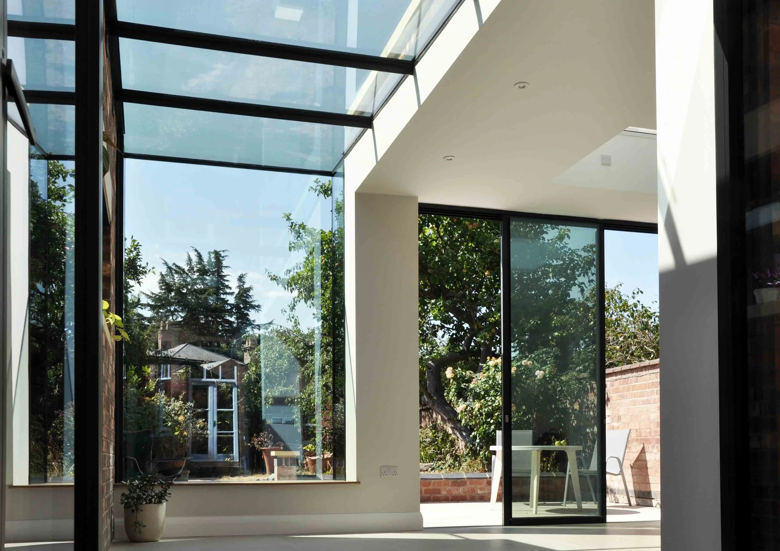 Unity Architects and Maxlight structural glass roof with oriel window and slim frame sliding doors