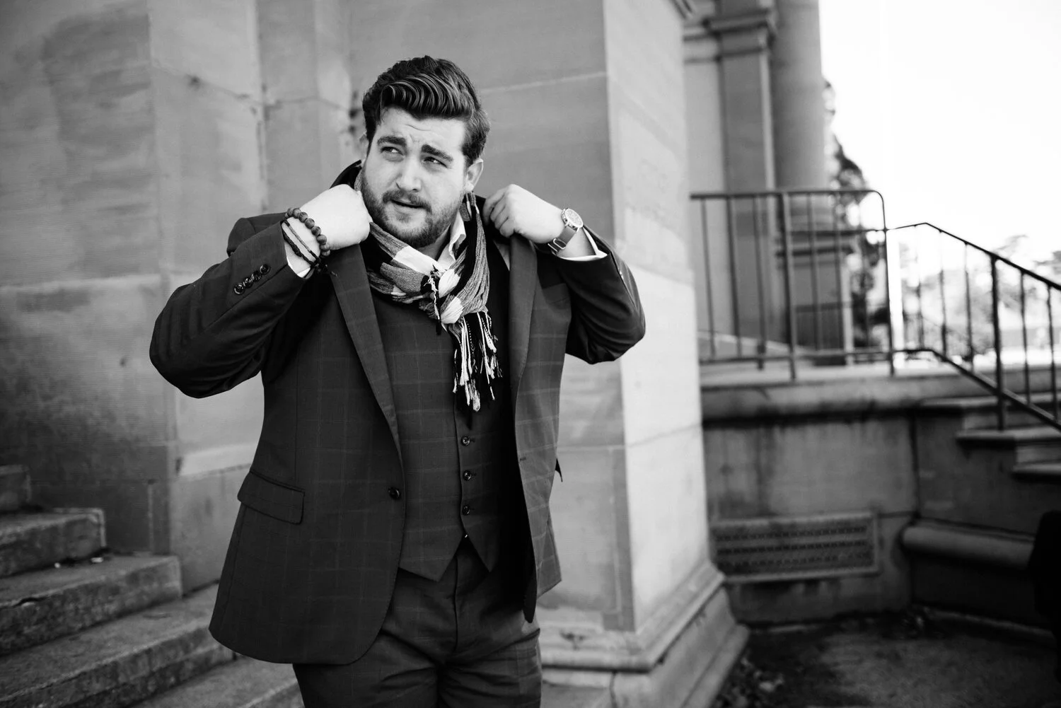 Alex Frankel in a Three piece suit and a linen scarf putting his suit jacket on in Golden Gate Park in San Francisco.