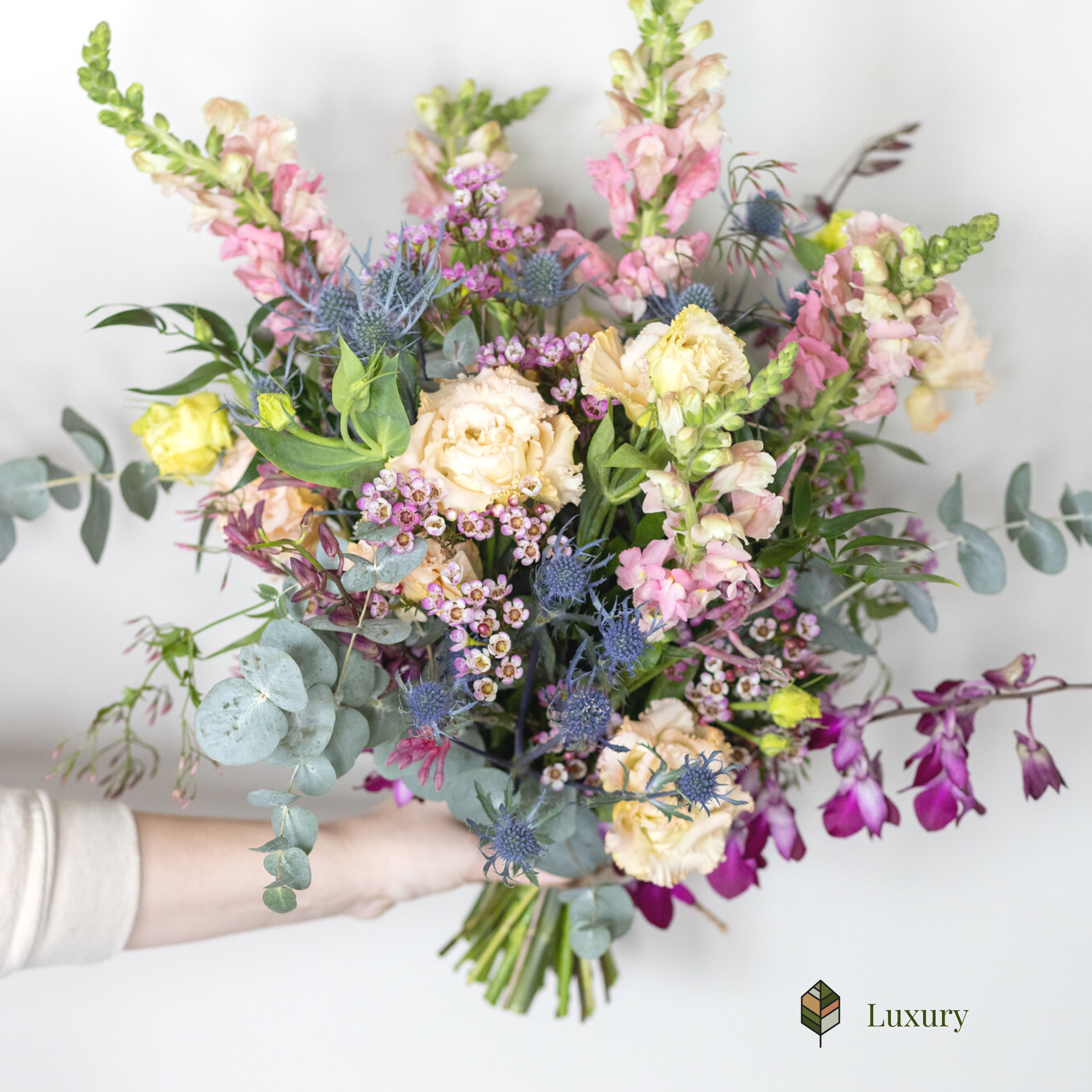 A person holding a hand-tied bouquet from Bloom Culture.