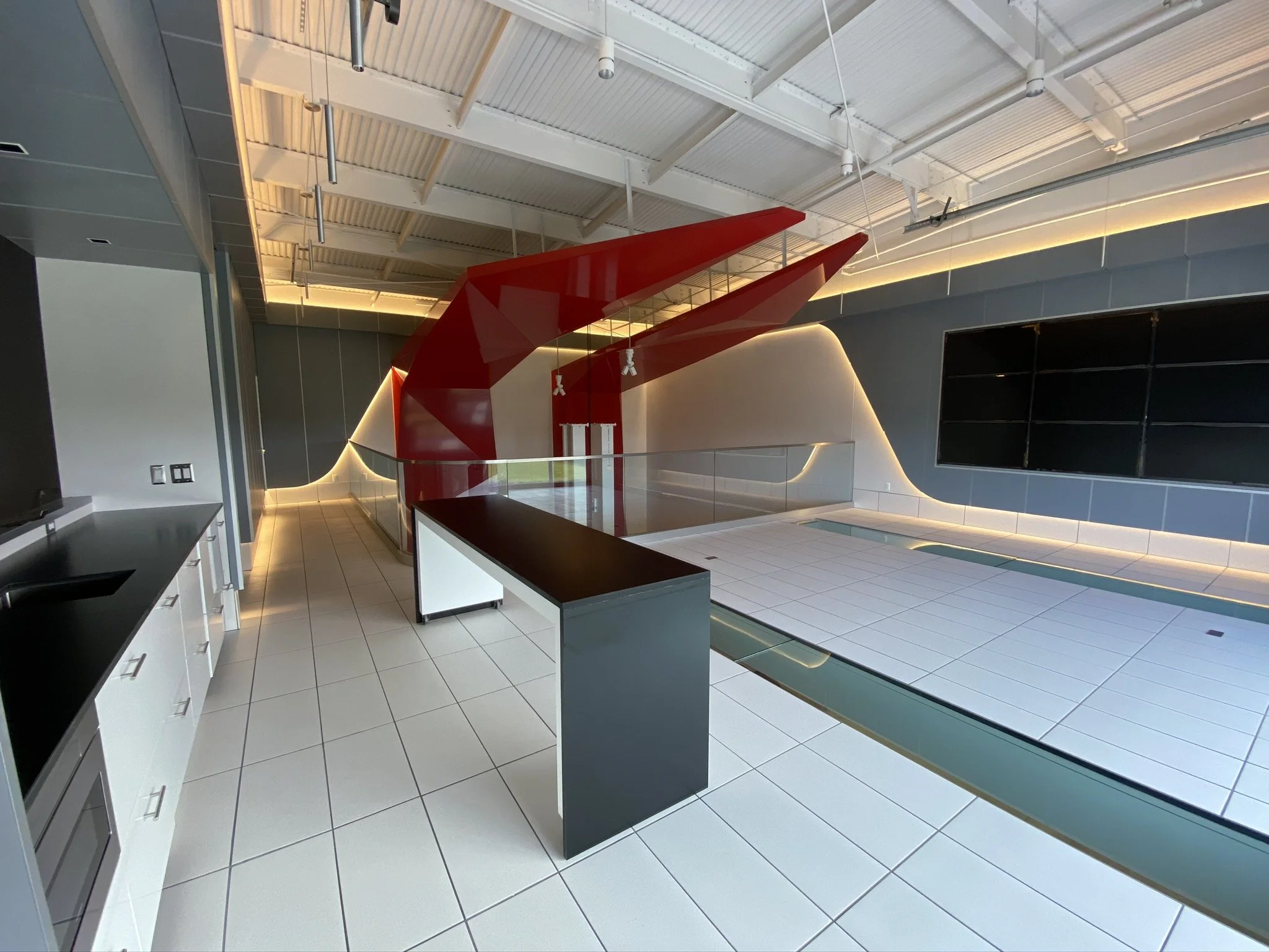 The interior of a room with black countertops and a decorative red piece hanging from the ceiling.