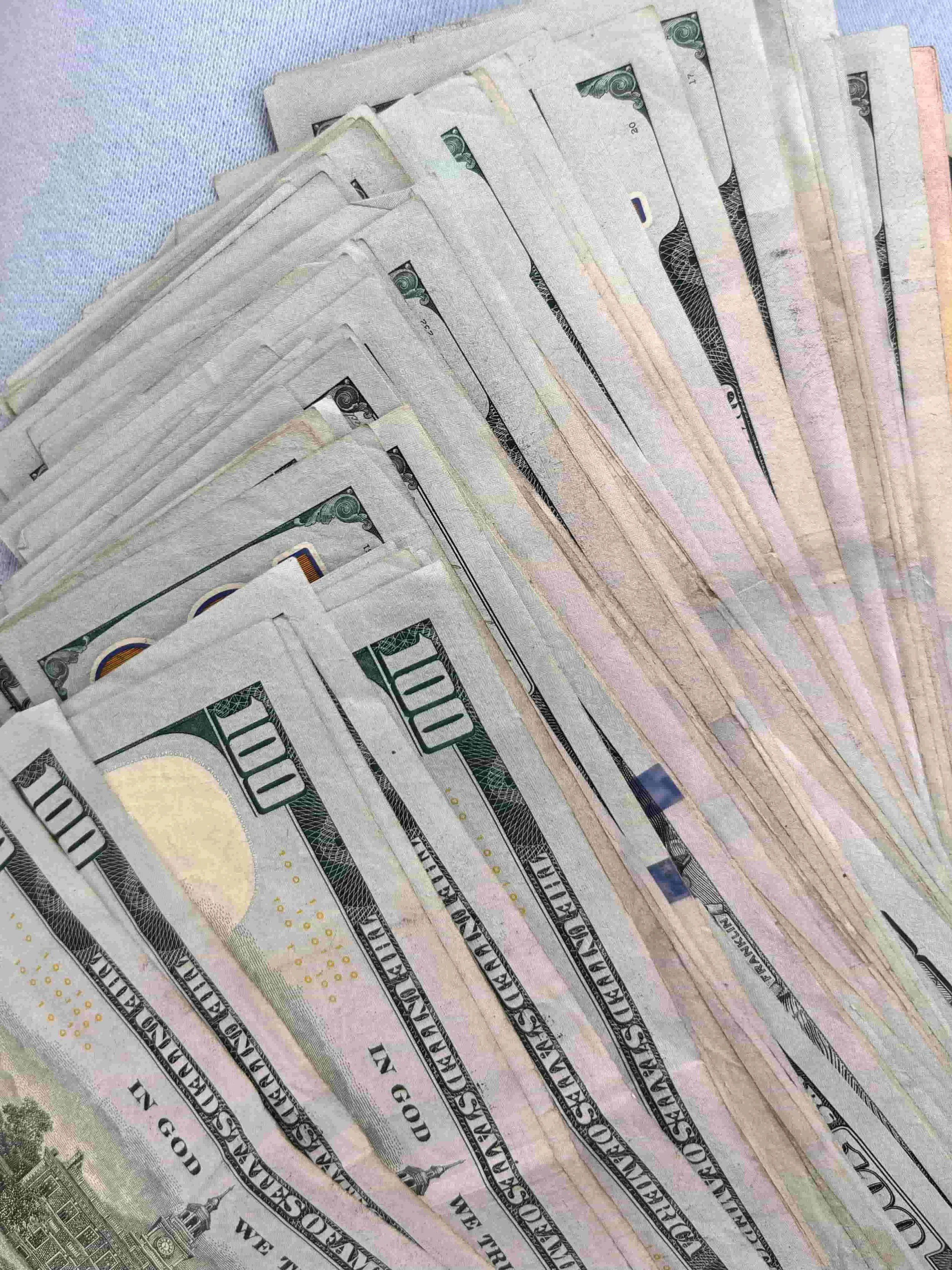 Fanned out US hundred dollar bills representing the cost savings of hiring a fractional marketing agency versus a full-time senior marketing hire.