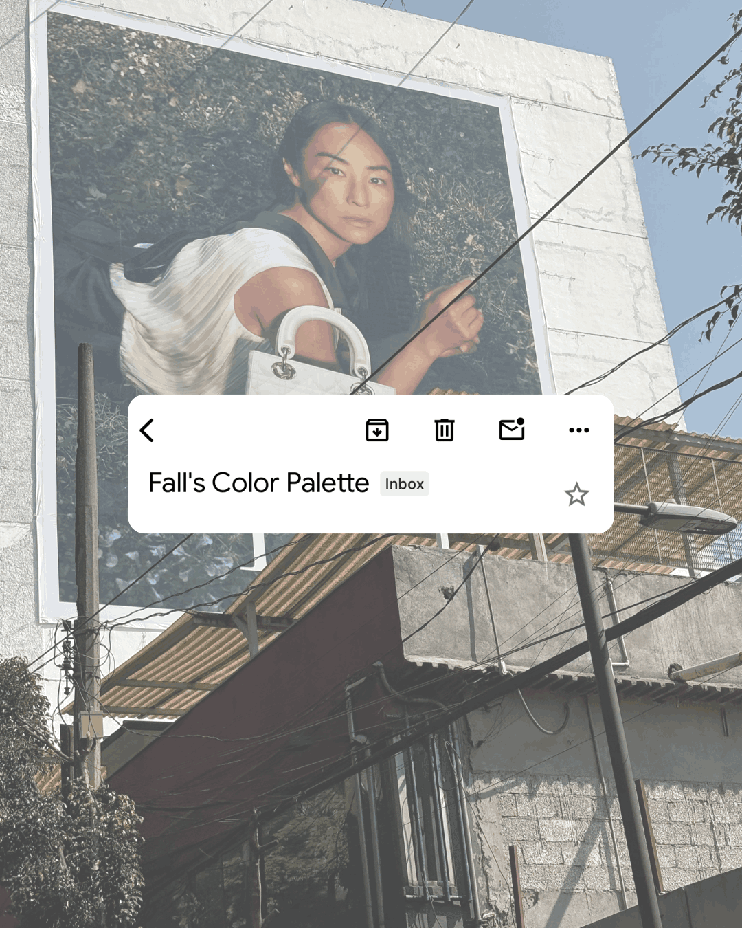 Large fashion advertisement billboard on the side of a building showing a woman posing with a handbag, overlaid with an email inbox notification reading 'Fall's Color Palette' — illustrating out-of-context, disconnected marketing messaging.