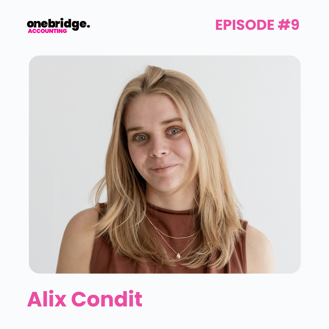 Headshot of a woman with blonde hair, wearing a sleeveless brown top and layered necklaces, smiling softly at the camera.