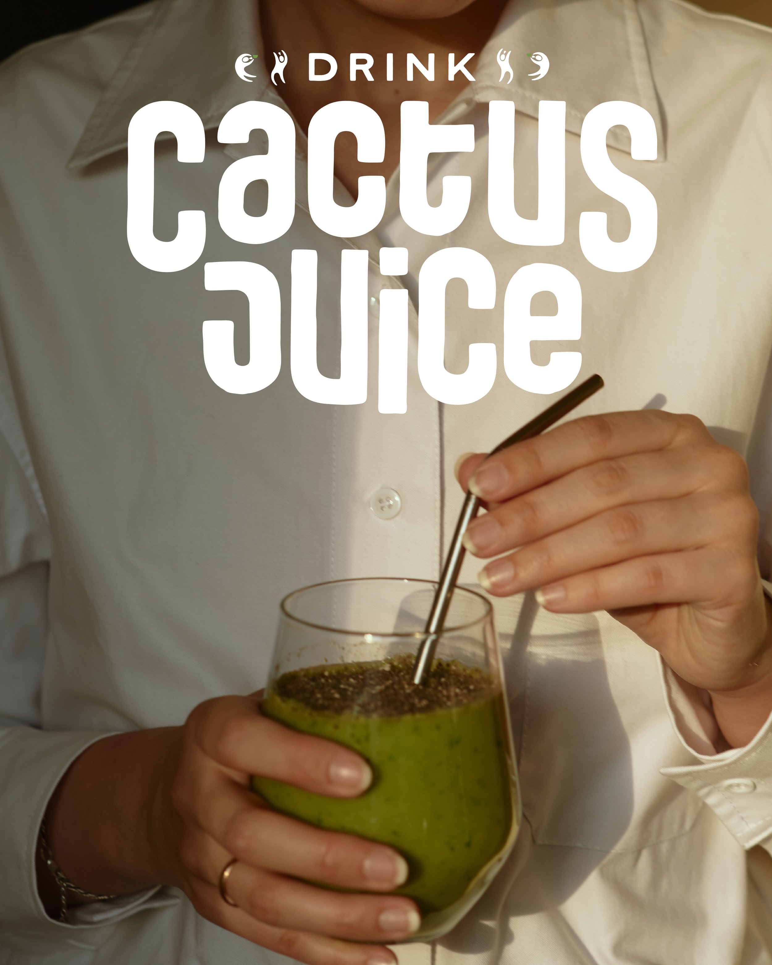 Person in a white shirt holding a glass of green cactus juice with a metal straw.
