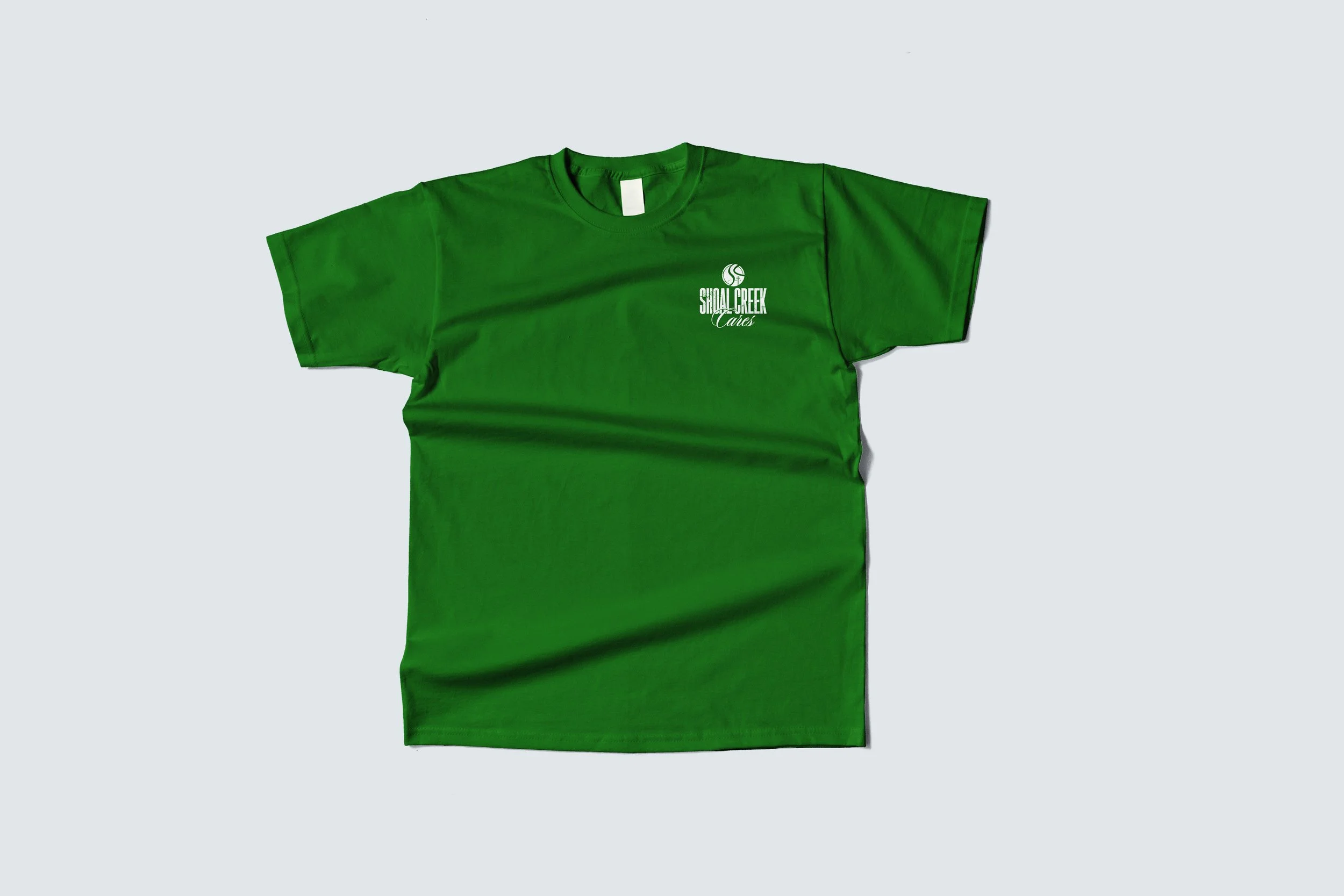 Green T-shirt with white logo and text reading 'Shosal Creek Cares' on the upper left side.