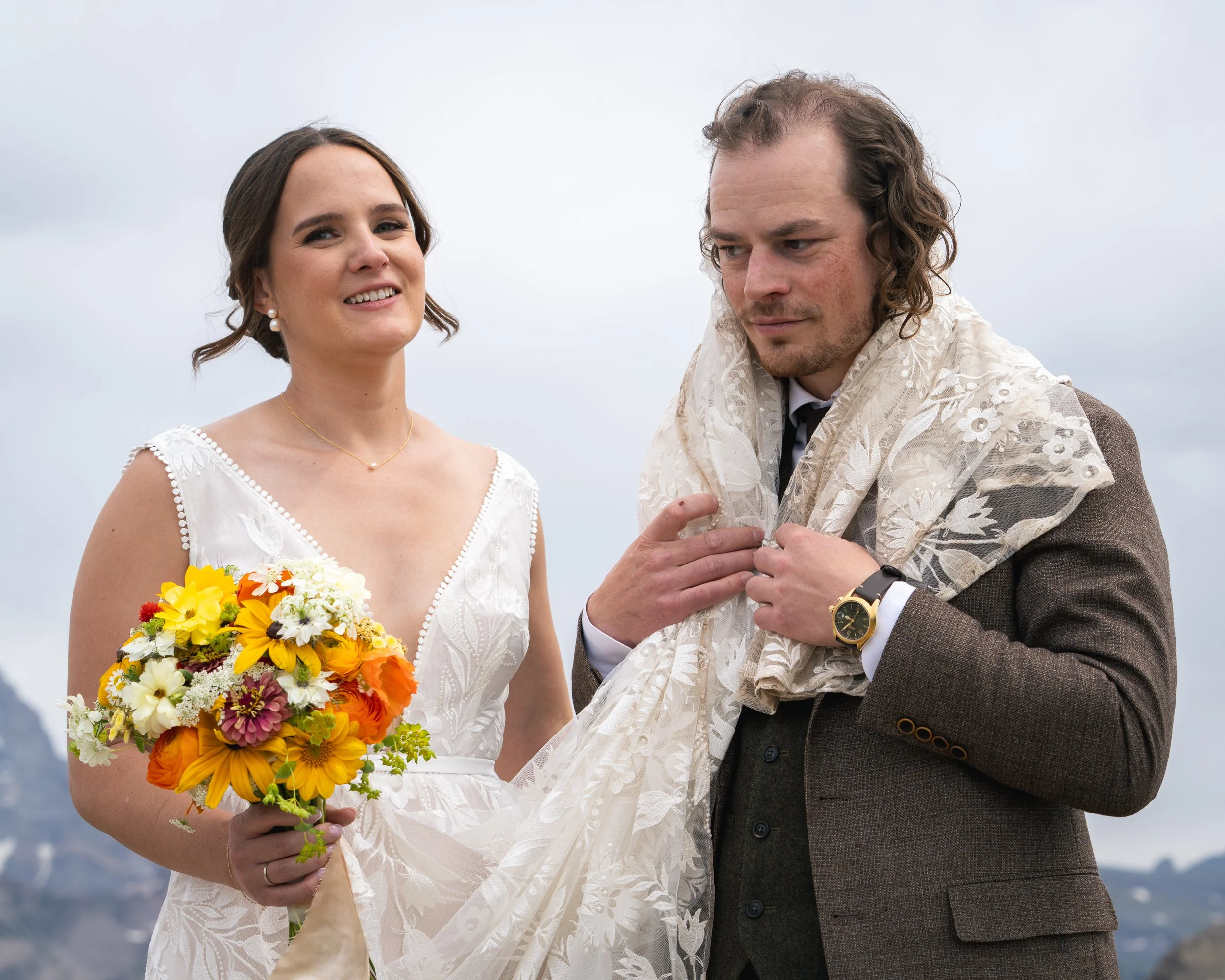 Grand Targhee Resort, documentary Wedding photography; groom has bride's train wrapped around shoulders