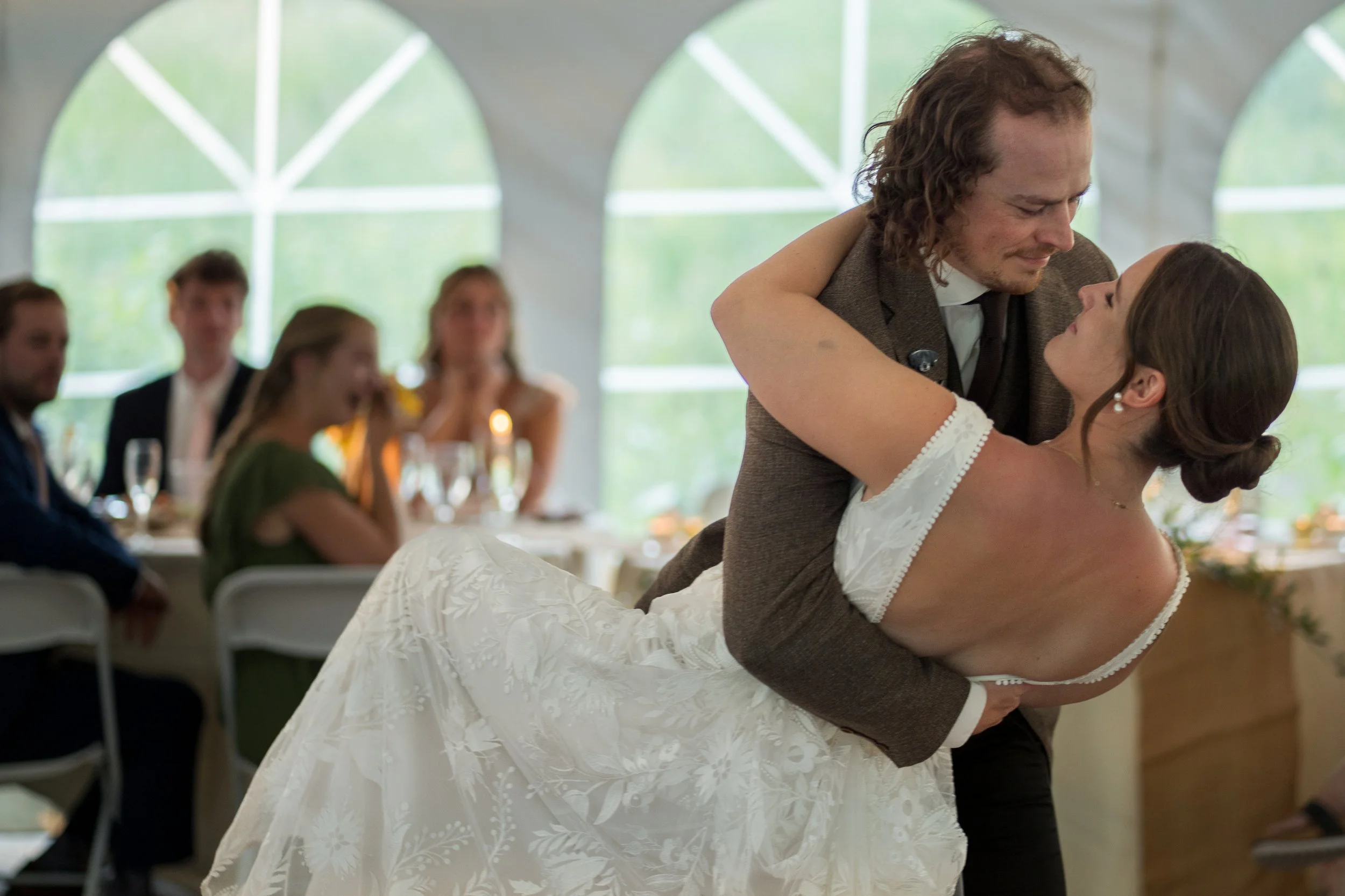 Grand Targhee Resort, documentary Wedding photography; groom dipping bride during first dance, guests in background