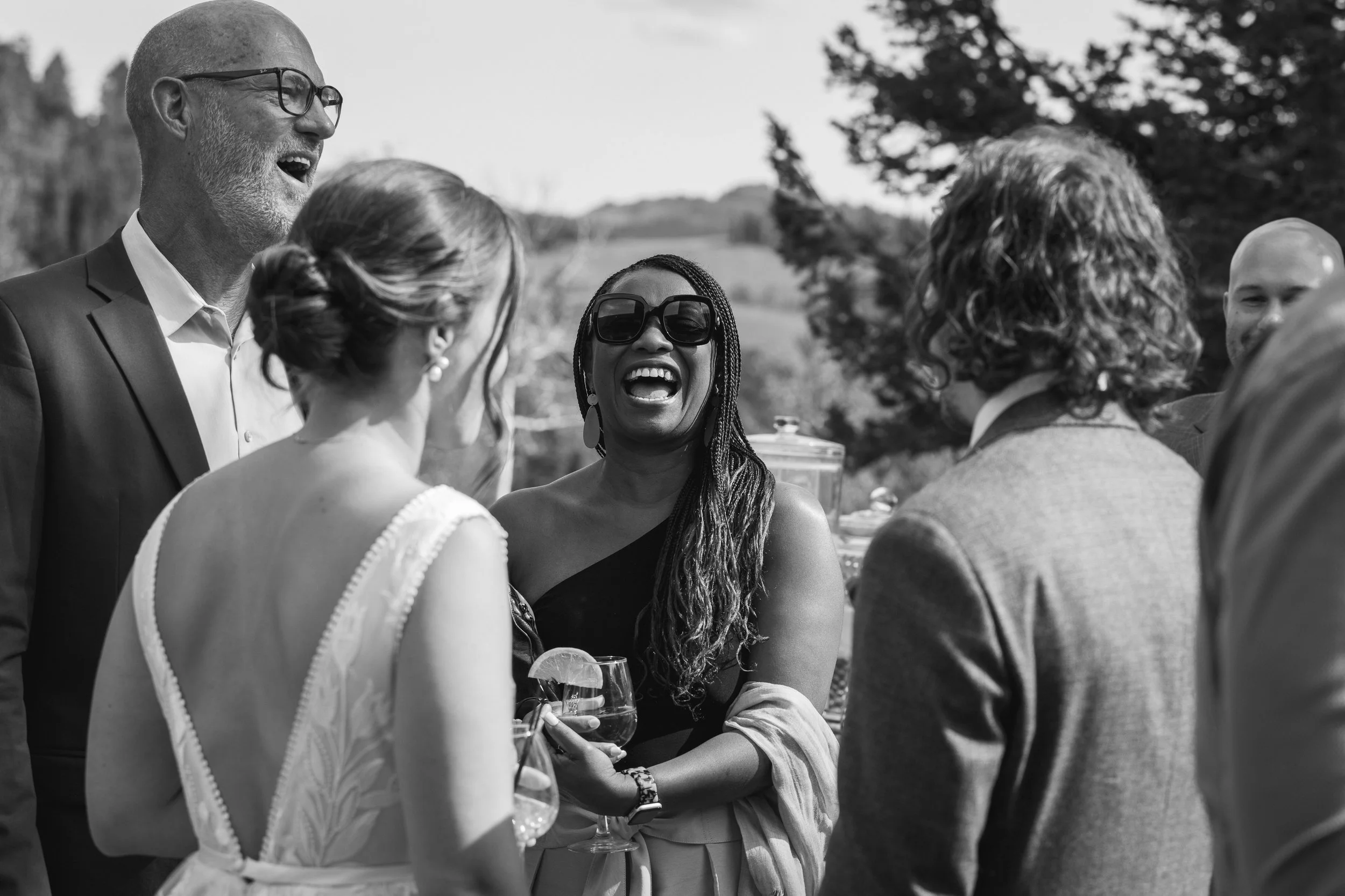 Grand Targhee Resort, documentary Wedding photography; bride and groom share a moment with guests, holding a drink and laughing