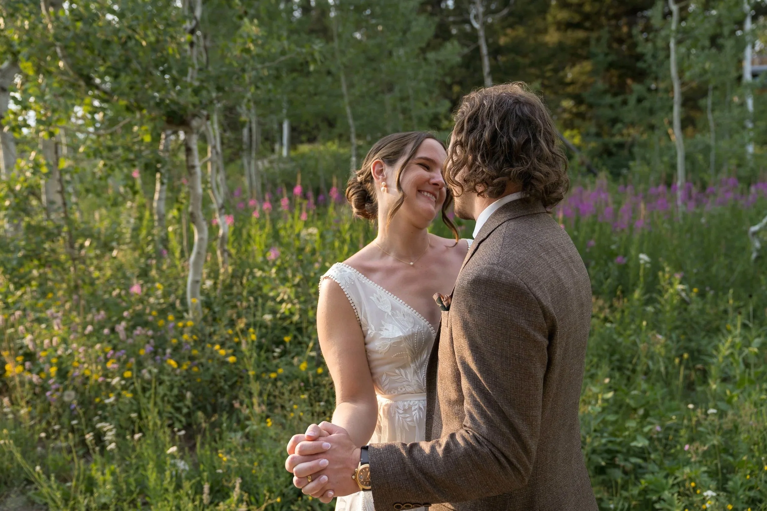 Grand Targhee Resort, documentary Wedding photography; groom and bride in dancing position with wildflowers in the background