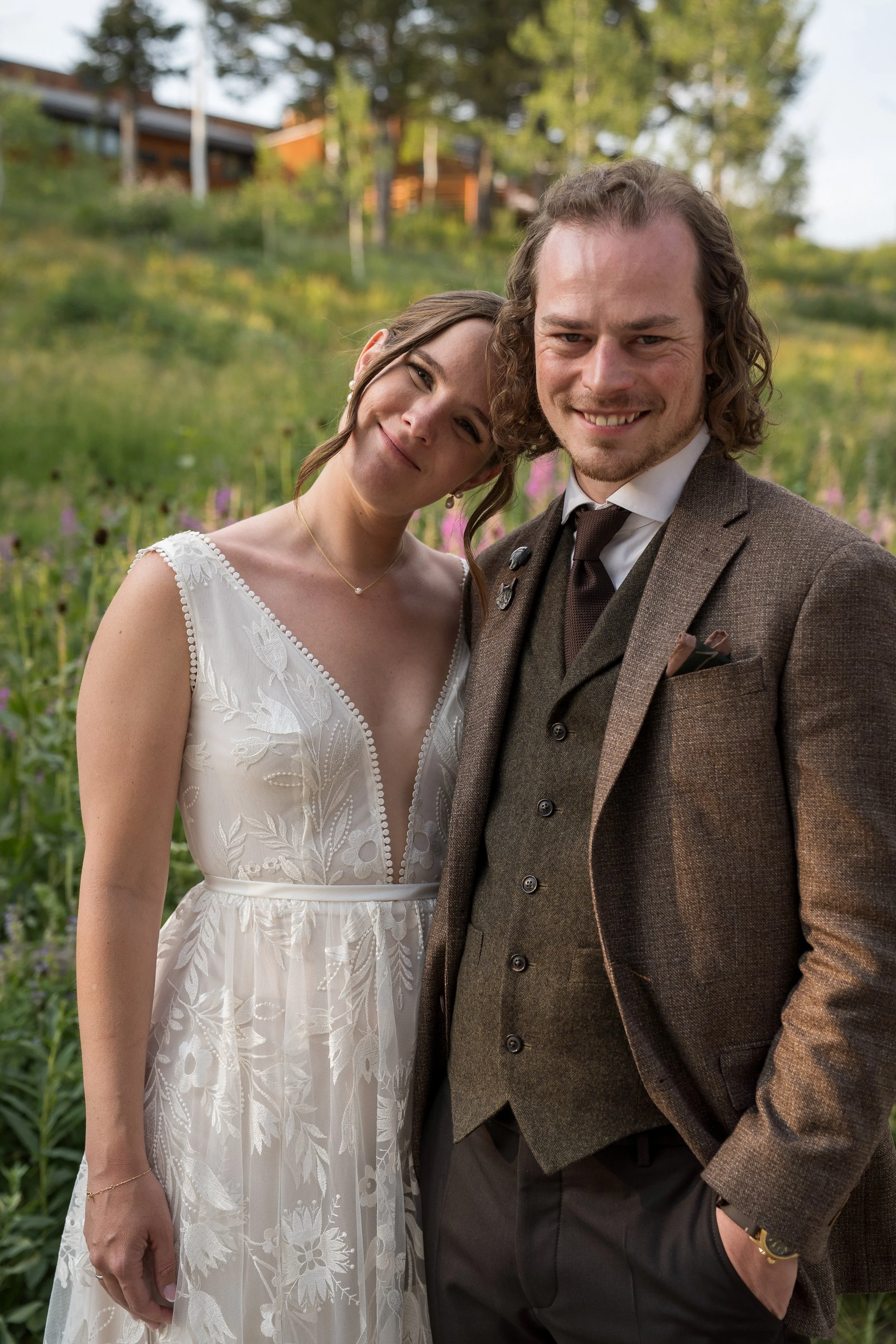 Grand Targhee Resort, documentary Wedding photography; bride and groom smiling at camera, bride with head tipped toward groom, wildflowers in teh background