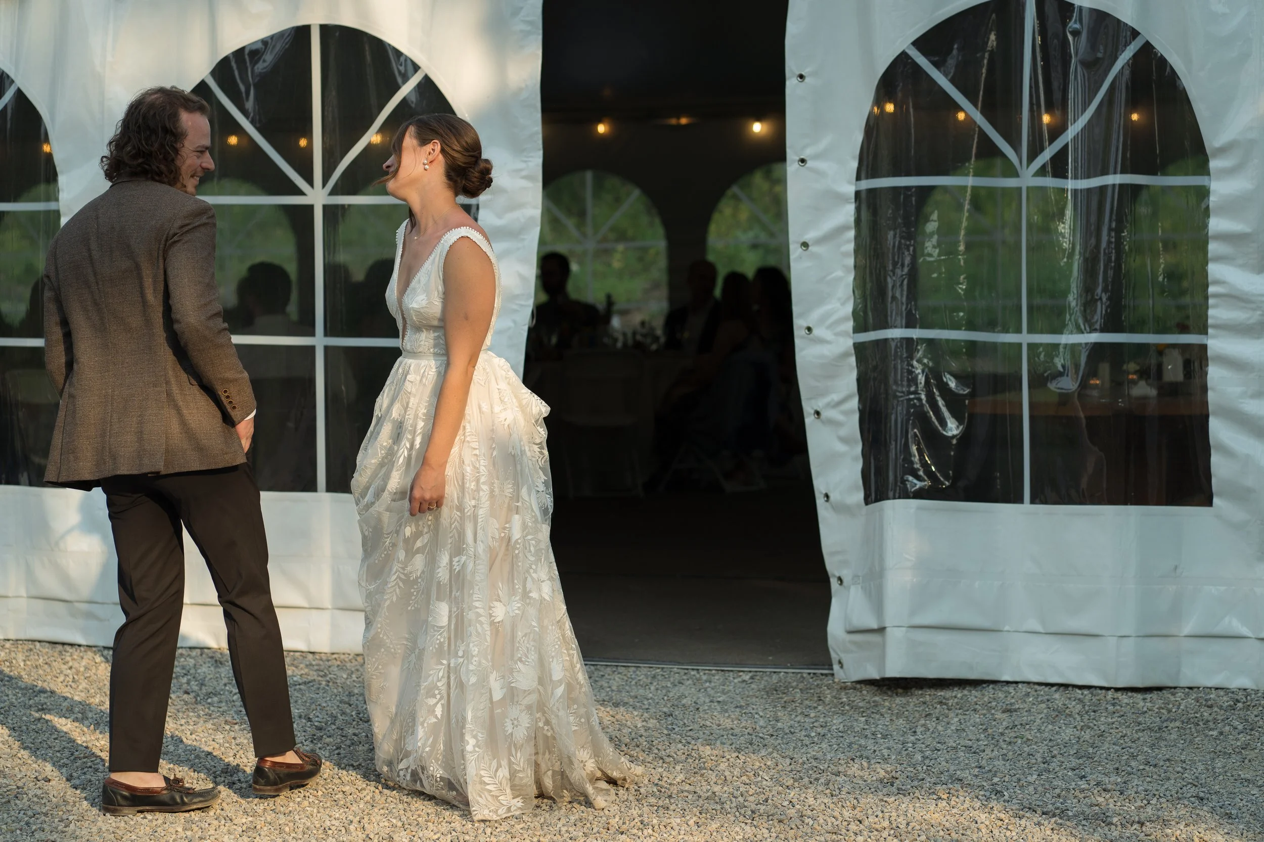 Grand Targhee Resort, documentary Wedding photography; bride and groom standing outside reception tent laughing with each other