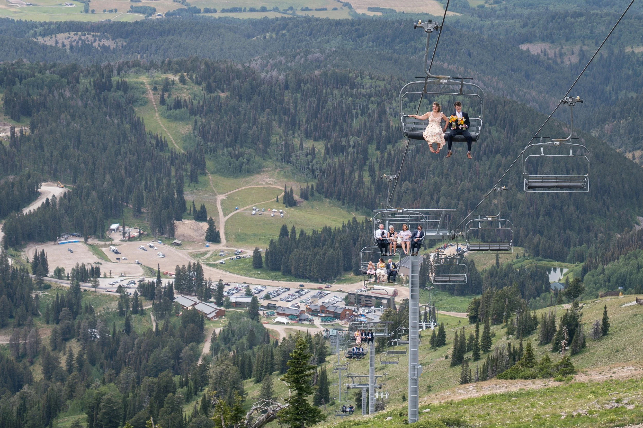 Grand Targhee Resort, documentary Wedding photography; family members and wedding party in chairs along the ski lift going up the mountain