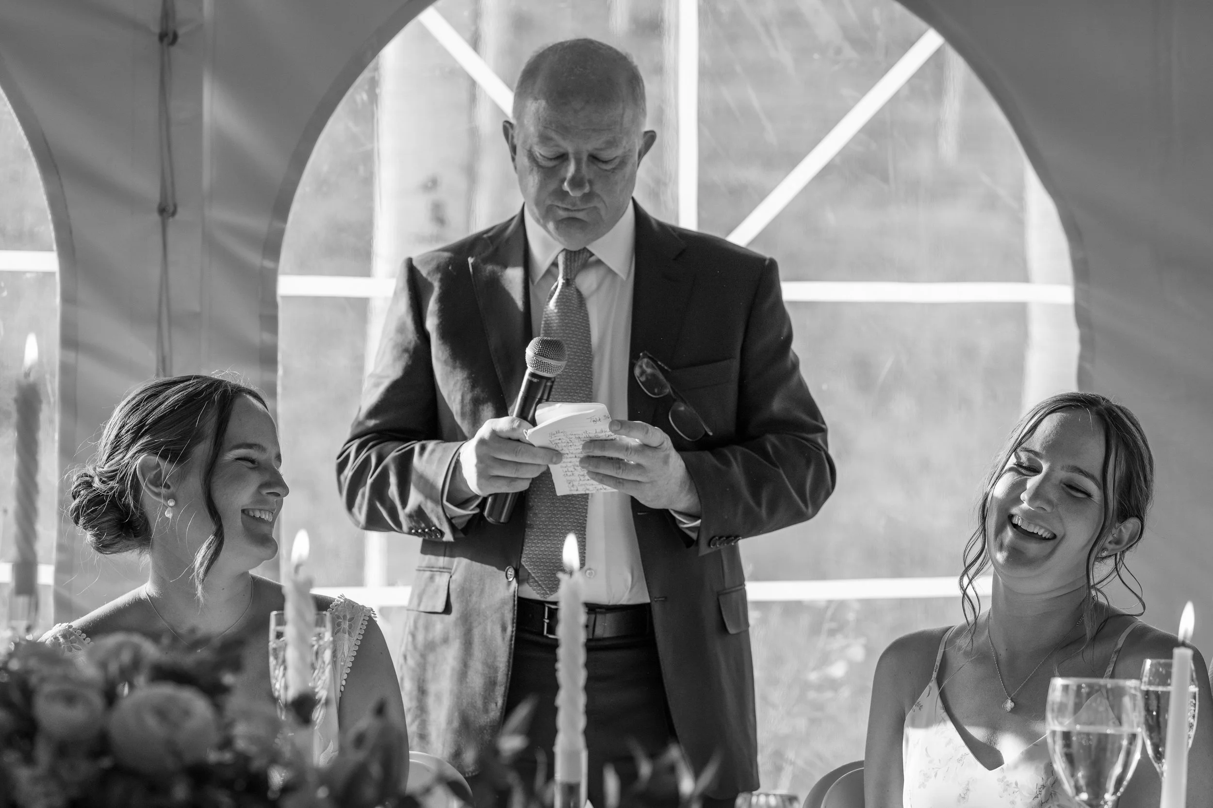 Grand Targhee Resort, documentary Wedding photography; bride and sister laughing with dad in the middle reading his toast